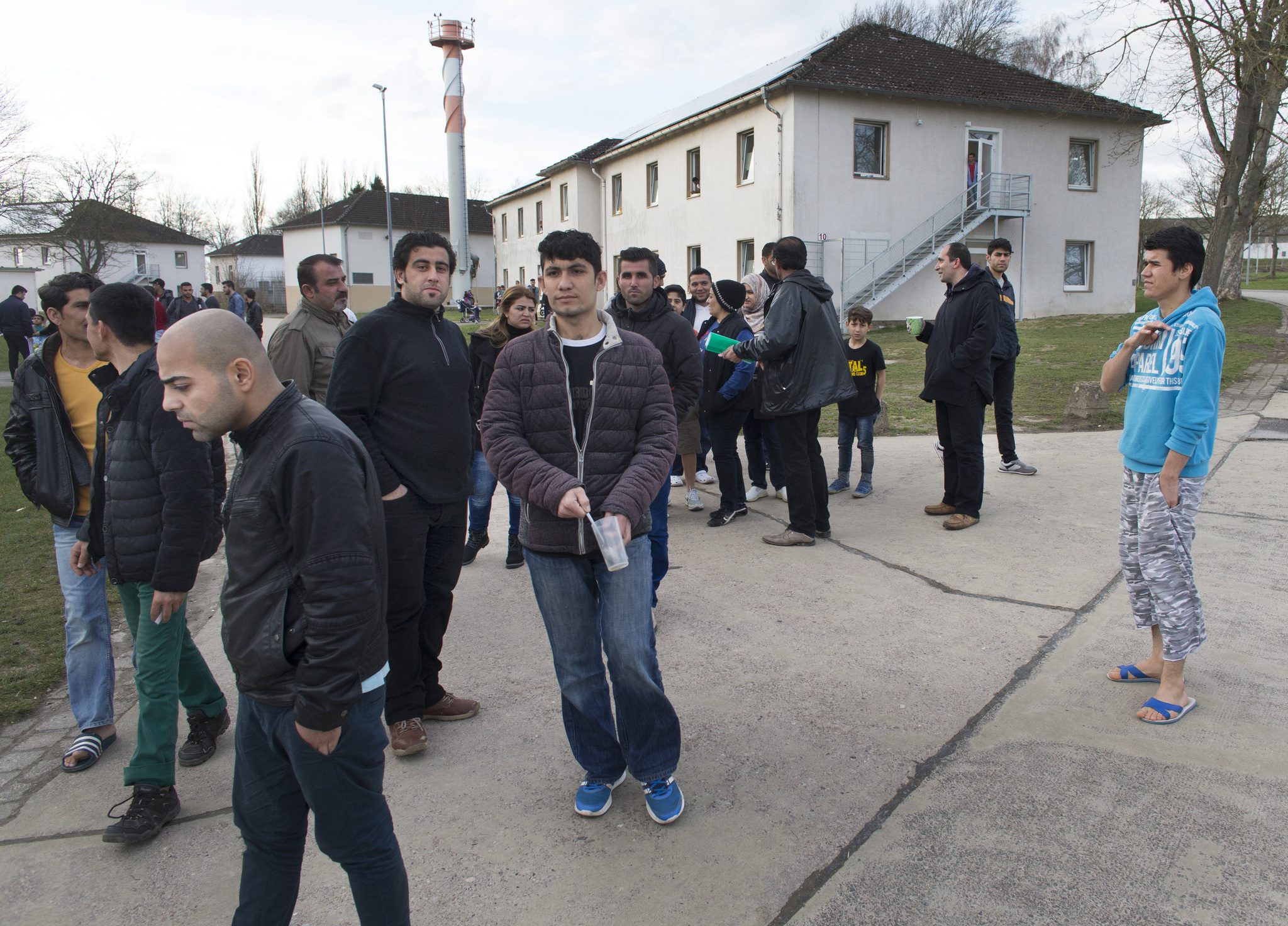 Upon hearing visitors were at the camp, refugees stream from their rooms and cafeteria at a former military barracks that has been converted into a center for refugees in Höxter, Germany. The center is about 225 miles west of Berlin. An overwhelming majority of the refugees there are from Syria, with some Iraqi and Afghanis as well. Image by Mark Hoffman. Germany, 2016. Media file: jordan_6.jpg