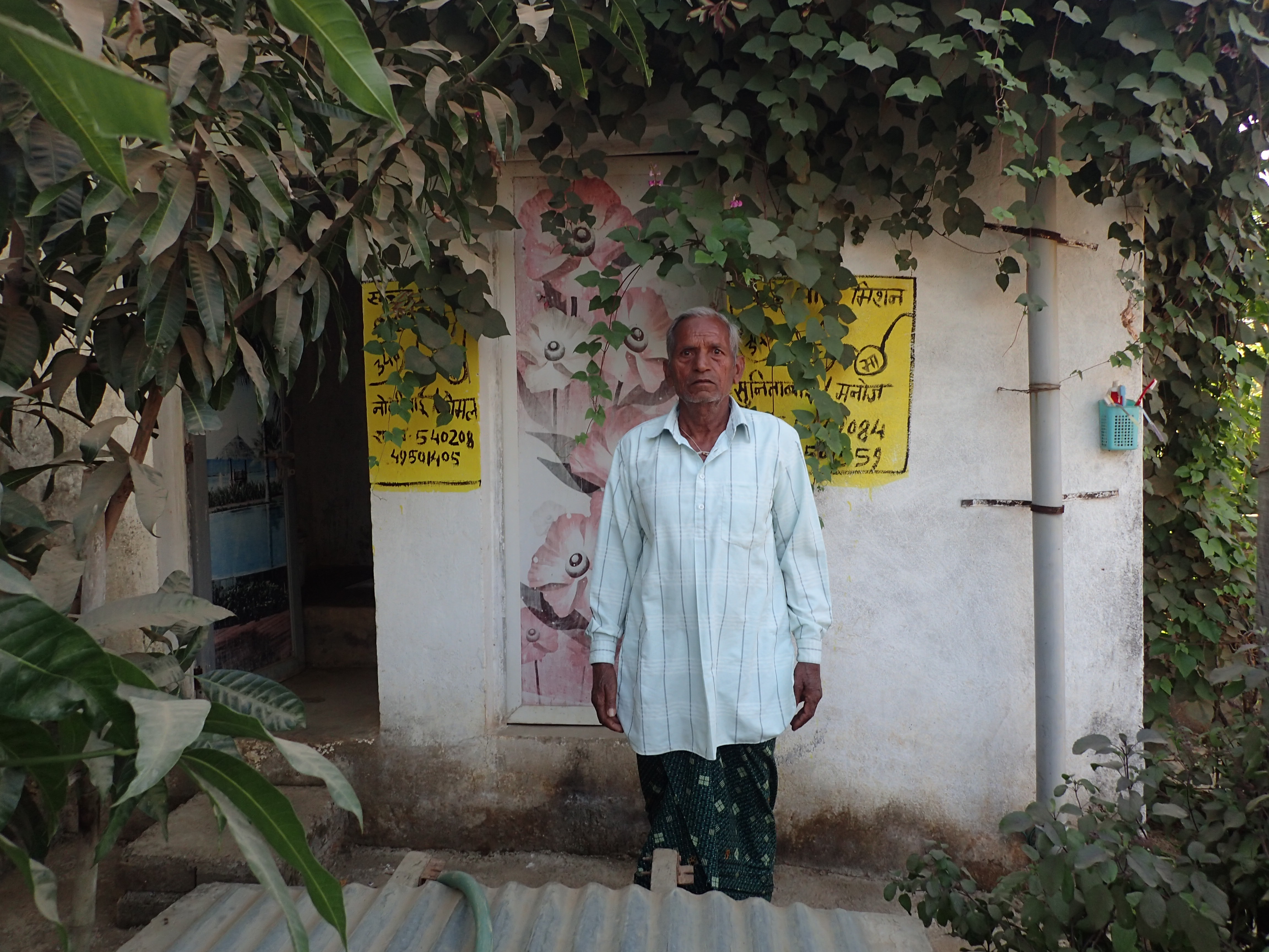 In Pihrid, a villager stands in front of two latrines he was ordered to construct as part of a government sanitation scheme. Each latrine costs Rs 50,000, or about $770. Image by Yardain Amron. India, 2017. In Pihrid, a villager stands in front of two latrines he was ordered to construct as part of a government sanitation scheme. Each latrine cost Rs 50,000, or about $770. Image by Yardain Amron. India, 2017.