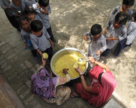 A meal of "sweat rice" made with rice, lentils and some vegetables being served to primary school children at a government-run girls' school in the village of Dujanna, Haryana. Image by Rhitu Chatterjee. India, 2014. Media file: serving_kids2.jpg
