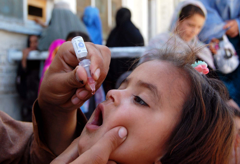 Health worker administrates polio-vaccine drops to a child during anti-polio immunization campaign at Pak-Afghan Border on April 08, 2015 in Chaman. Image by Shutterstock. Pakistan, 2015. Health worker administrates polio-vaccine drops to a child during anti-polio immunization campaign at Pak-Afghan Border on April 08, 2015 in Chaman. Image by Shutterstock. Pakistan, 2015.