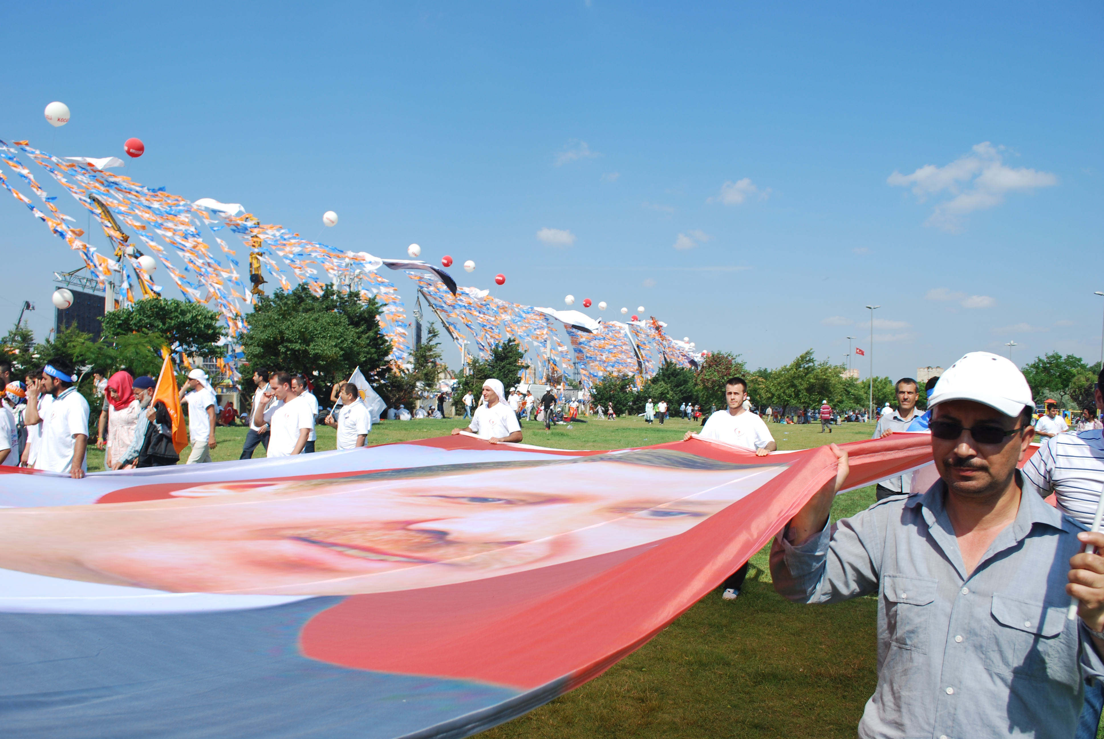 Supporters of the Justice and Development Party carry a flag depicting Prime Minister Recep Tayyip Erdogan at a 2013 rally. Image by Jenna Krajeski. Turkey, 2014. Media file: dsc_0133.jpg