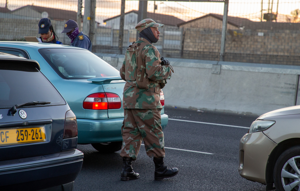 Members of the South African Police Service and the South African National Defence Force deploy at a roadblock on the busy R300 highway. Image by Roger Sedres / Shutterstock. South Africa, 2020. Members of the South African Police Service and the South African National Defence Force deploy at a roadblock on the busy R300 highway. Image by Roger Sedres / Shutterstock. South Africa, 2020.