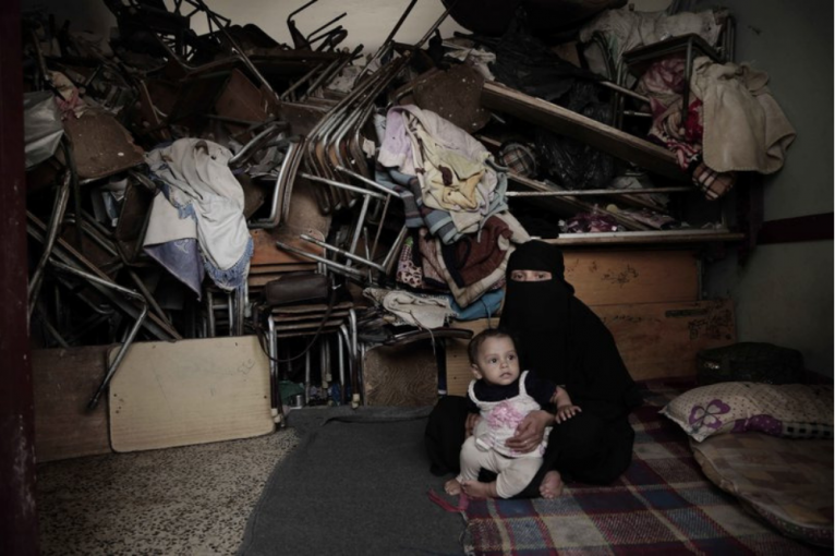 A woman sits with her baby inside a shelter for displaced persons in Ibb. Image by Nariman El-Mofty/AP Photo. Yemen, 2018. A woman sits with her baby inside a shelter for displaced persons in Ibb. Image by Nariman El-Mofty/AP Photo. Yemen, 2018.