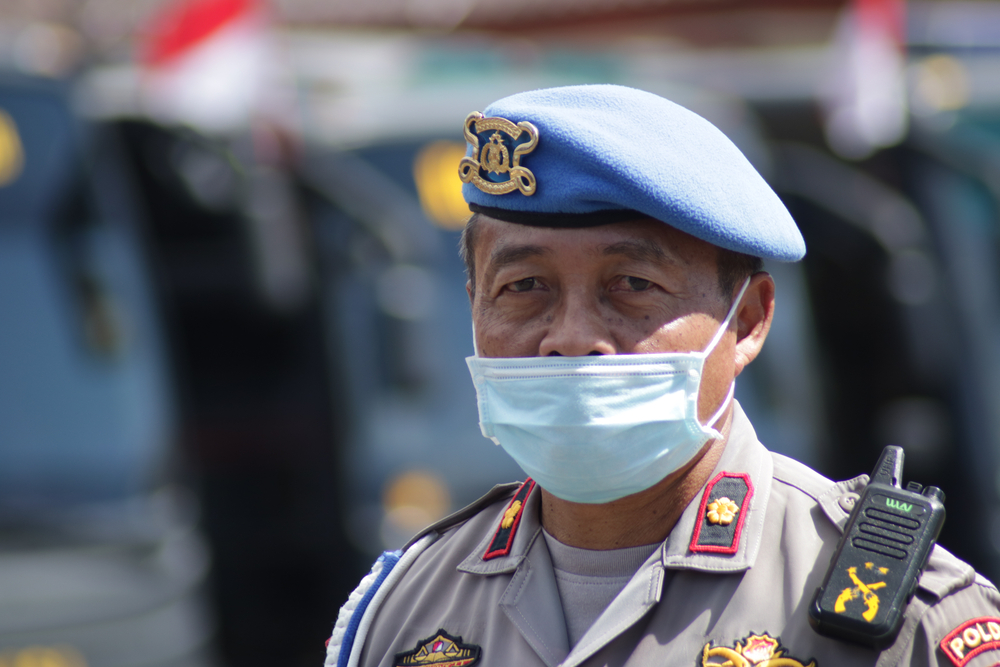 An Indonesian police officer wears a mask while on duty. Image by Herwin Bahar / Shutterstock. Indonesia, 2020. An Indonesian police officer wears a mask while on duty. Image by Herwin Bahar / Shutterstock. Indonesia, 2020.