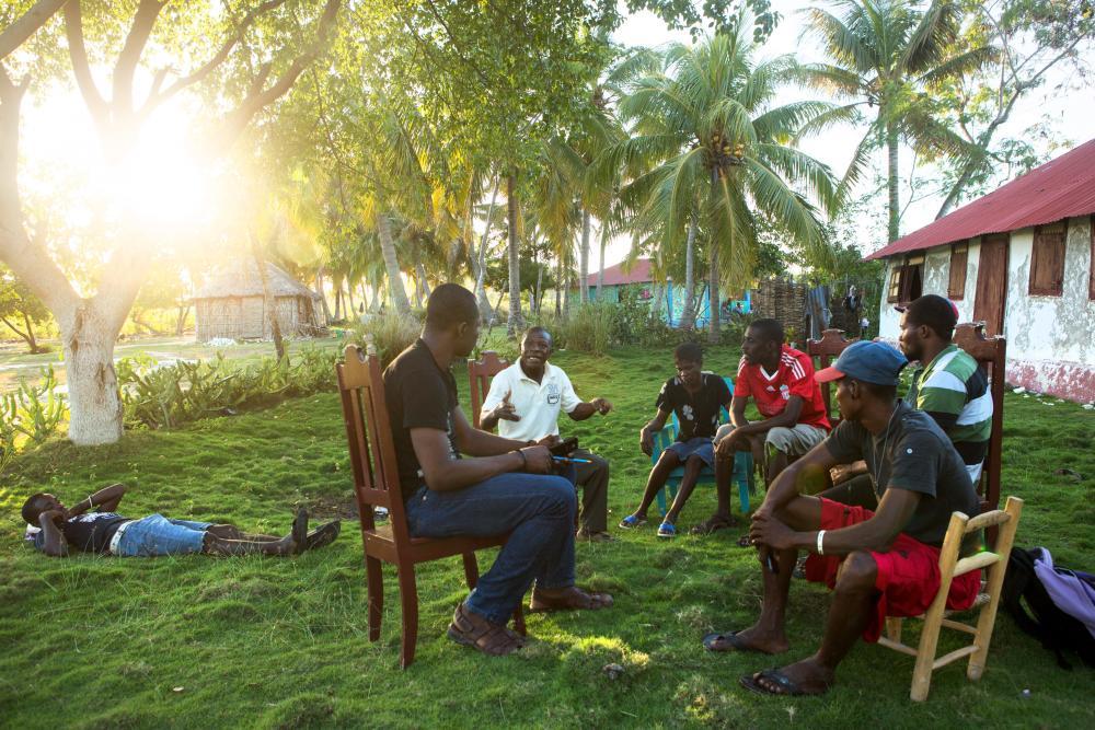Members of KOPI, a grassroots organization made up of four local groups to press the Haitian government for transparency and community participation in its development plans for the island of Ile-a-Vache, Haiti, meet together on the island. Image by Allison Shelley. Haiti, 2014.