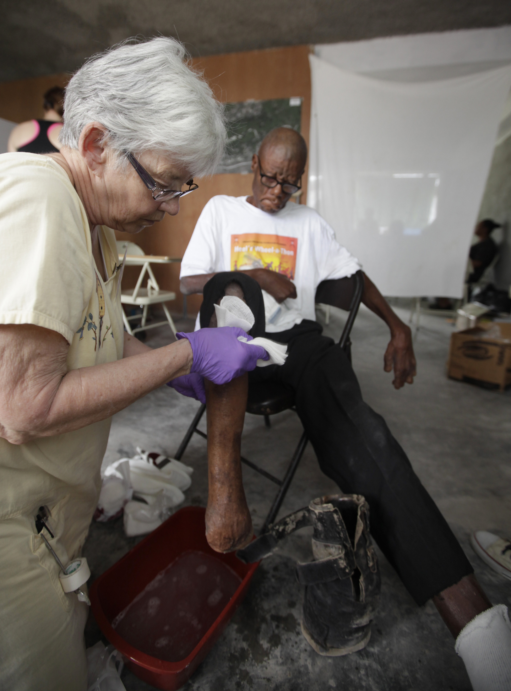 Nurse Jan Palmer of Minnesota washes the foot of leprosy patient Jean Stefen Youyoute, 67. Image by Mary Chind. Haiti, 2013. Media file: dmrdc5-69kvspu5krkmd4hdog1_original.jpg