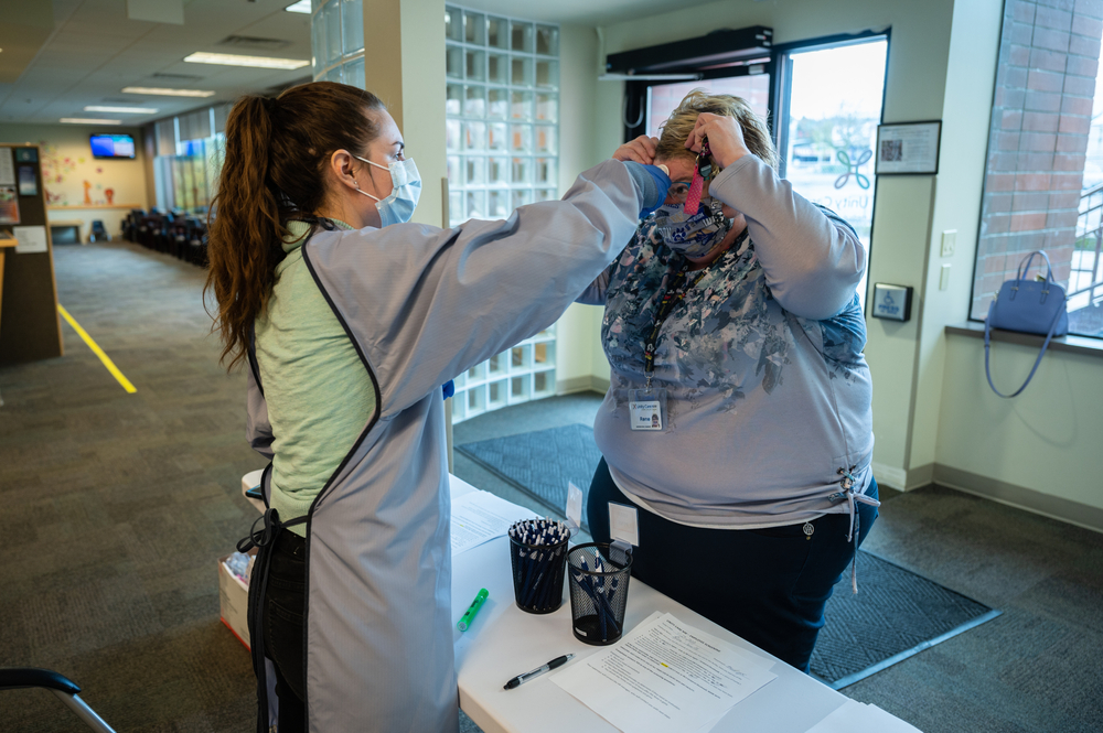 A staff member at Unity Care NW has her temperture checked and signs off on her lack of COVID-19 symptoms prior to beginning her shift at the clinic. Image by Gregg Brekke / Shutterstock. United States, 2020. A staff member at Unity Care NW has her temperture checked and signs off on her lack of COVID-19 symptoms prior to beginning her shift at the clinic. Image by Gregg Brekke / Shutterstock. United States, 2020.