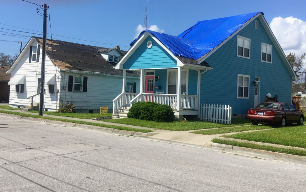 A home in Beaufort, North Carolina awaits roof repair. The tarp protects the home from further water damage. A shortage of contractors following the storm left many people waiting months for repairs. Image by Erika Layko. United States, 2018. A home in Beaufort, North Carolina awaits roof repair. The tarp protects the home from further water damage. A shortage of contractors following the storm left many people waiting months for repairs. Image by Erika Layko. United States, 2018.