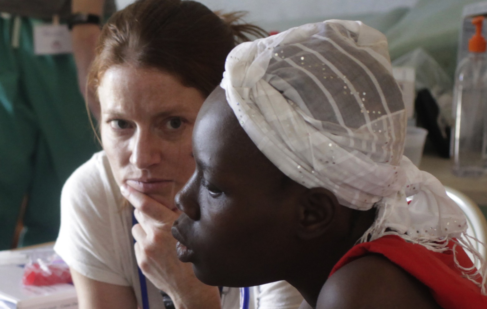 Dr. Ginny Ryan Buresh, a gynecologist from the University of Iowa, and a Haitian patient listen to an interpreter translate their discussion of health issues. Image by Mary Chind. Haiti, 2013. Media file: dmrdc5-69kvq14snvscj08oog1_original.jpg