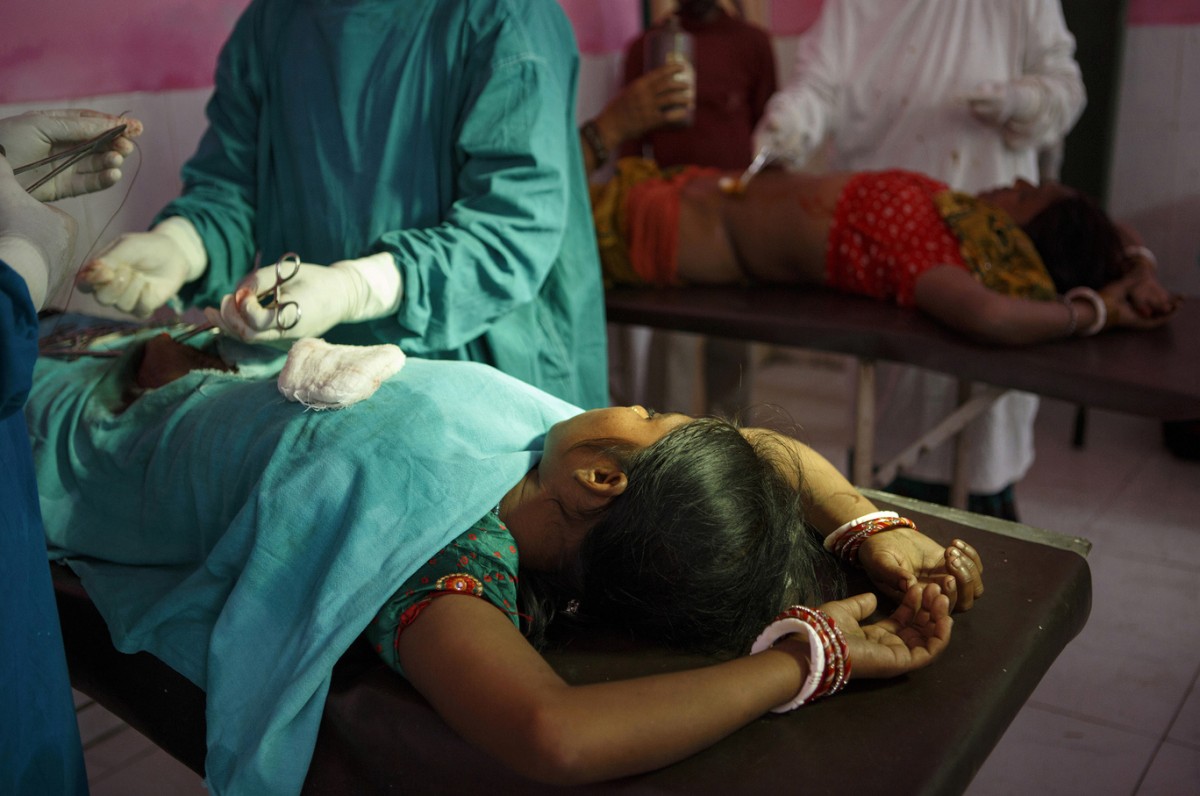 Women undergo sterilization operations at the Cheria Bariarpur Primary Health Centre in Bihar in December 2014. A few dozen women were sterilized at the facility that day. Image by Sarah Weiser. India, 2014. Media file: 41023659280-01-718481-1200x796.jpg