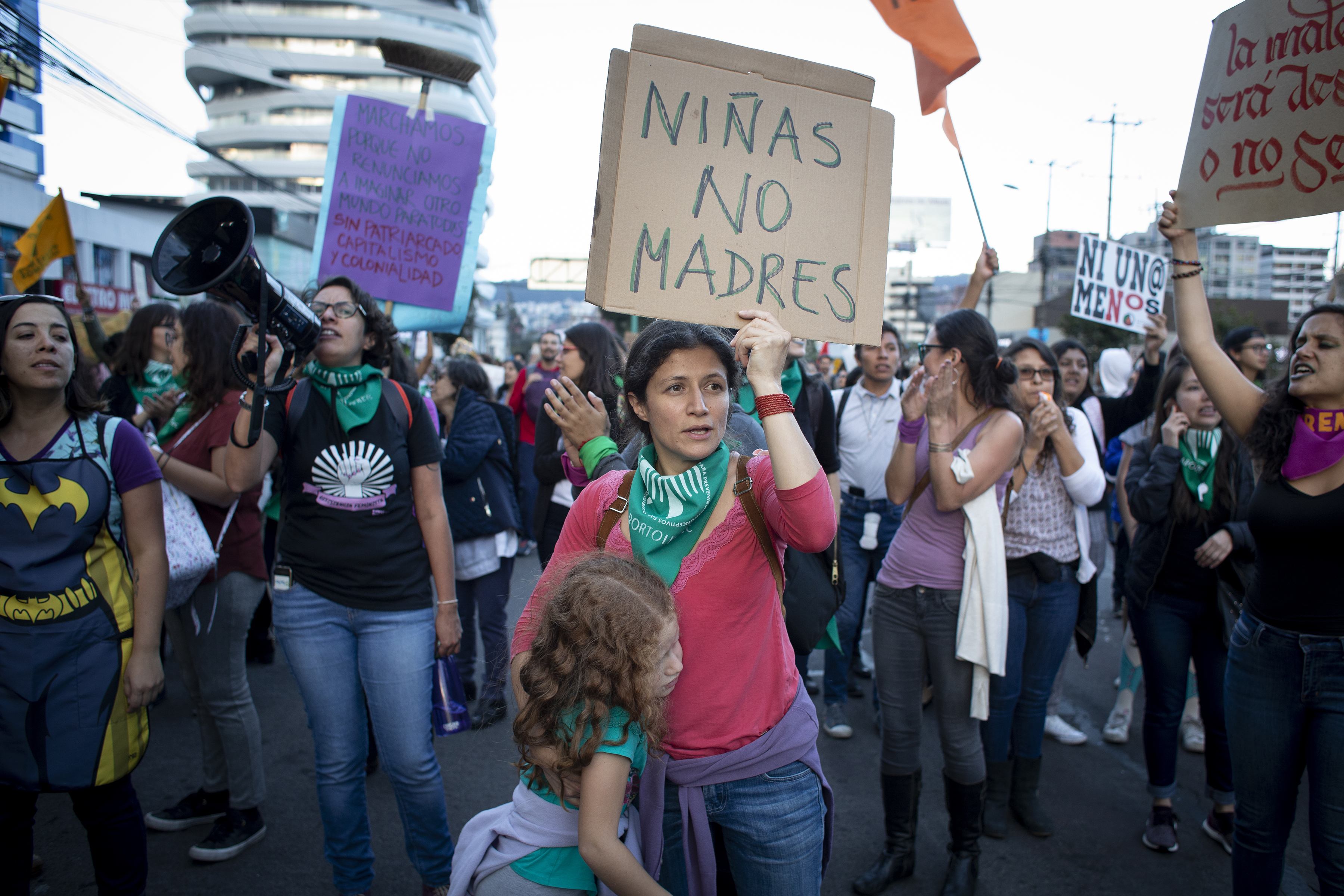 A woman hugs her daughter while holding a sign that says “Girls Not Mothers” in Quito, Ecuador. She marched with hundreds of women on March 8 for women's rights in Ecuador and around the world. Image by Dominique Riofrío. Ecuador, 2019. A woman hugs her daughter while holding a sign that says “Girls Not Mothers” in Quito, Ecuador. She marched with hundreds of women on March 8 for women's rights in Ecuador and around the world. Image by Dominique Riofrío. Ecuador, 2019.