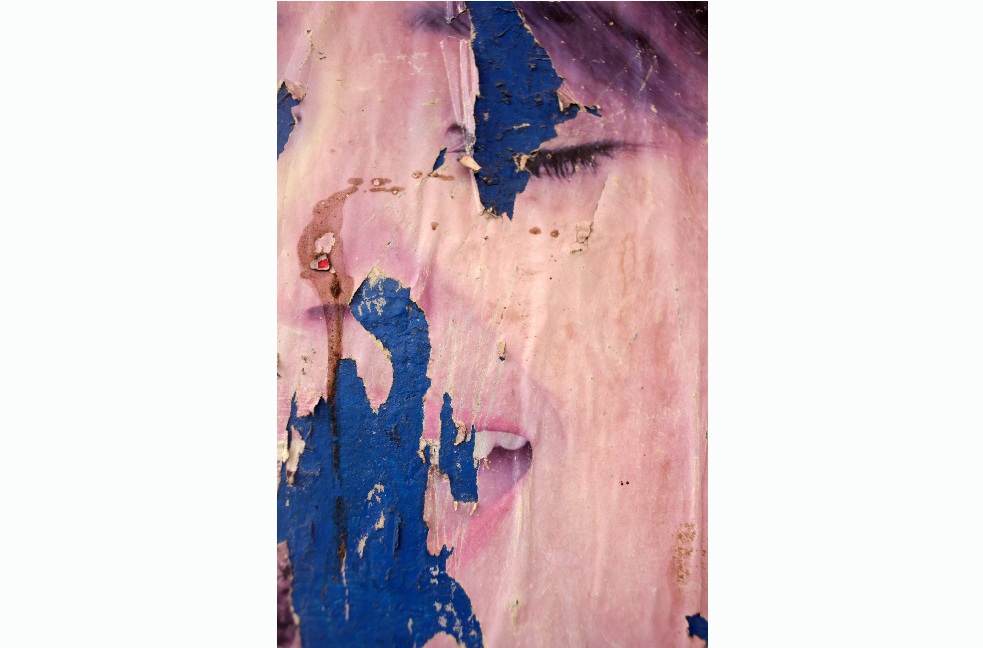 Poster from another era revealing an image of a woman. Image by Seamus Murphy. Afghanistan, 2012. Media file: seamusmurphy_landay.jpg