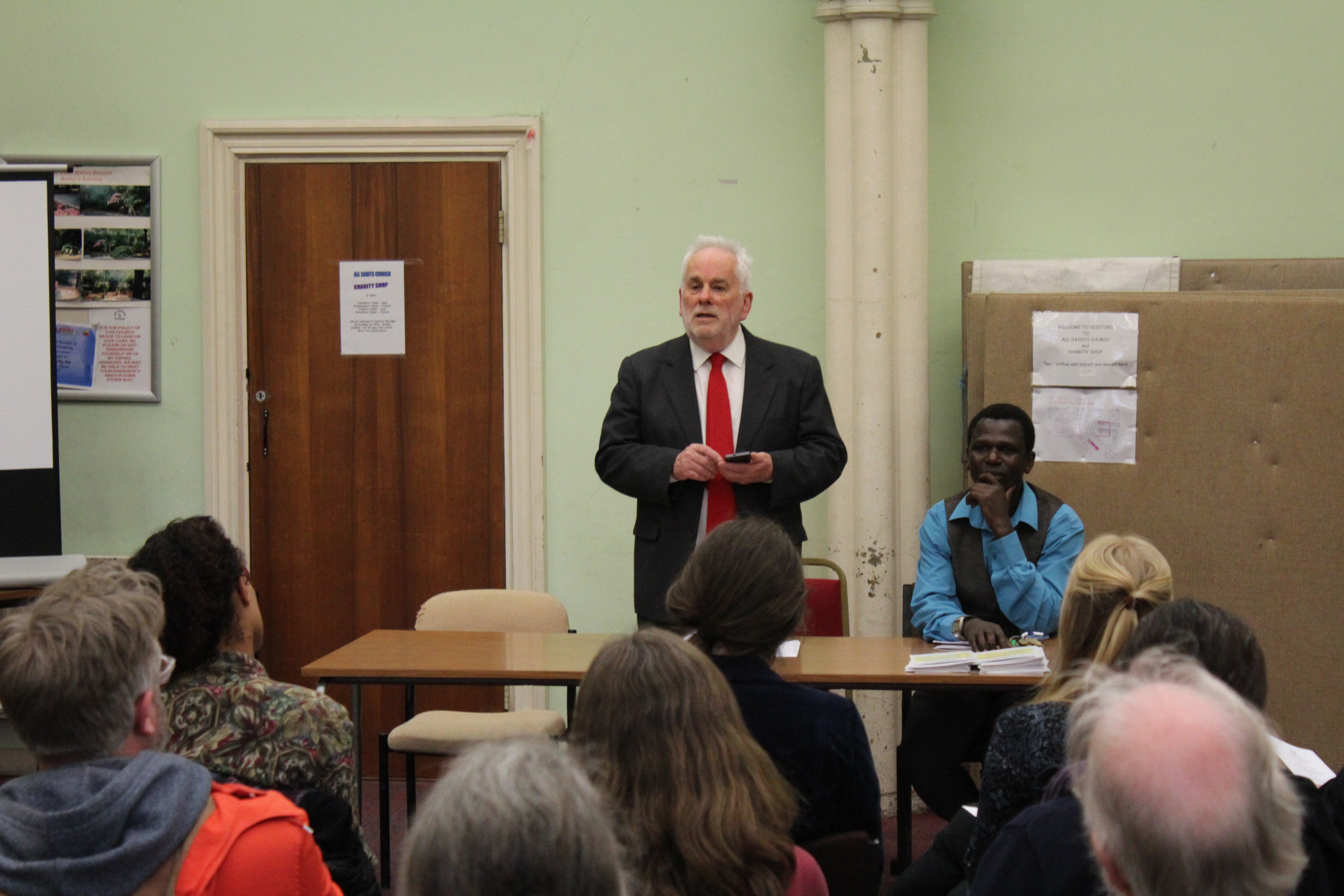 Michael Woolley (left) and John Bosco (right), chair and treasurer respectively of Friends Without Borders, at their annual general meeting on April 19, 2016. Friends Without Borders helps asylum seekers and immigrants with legal advice and practical aid. Image by Abe Kenmore. United Kingdom, 2016. Media file: wooley_and_bosco.jpg