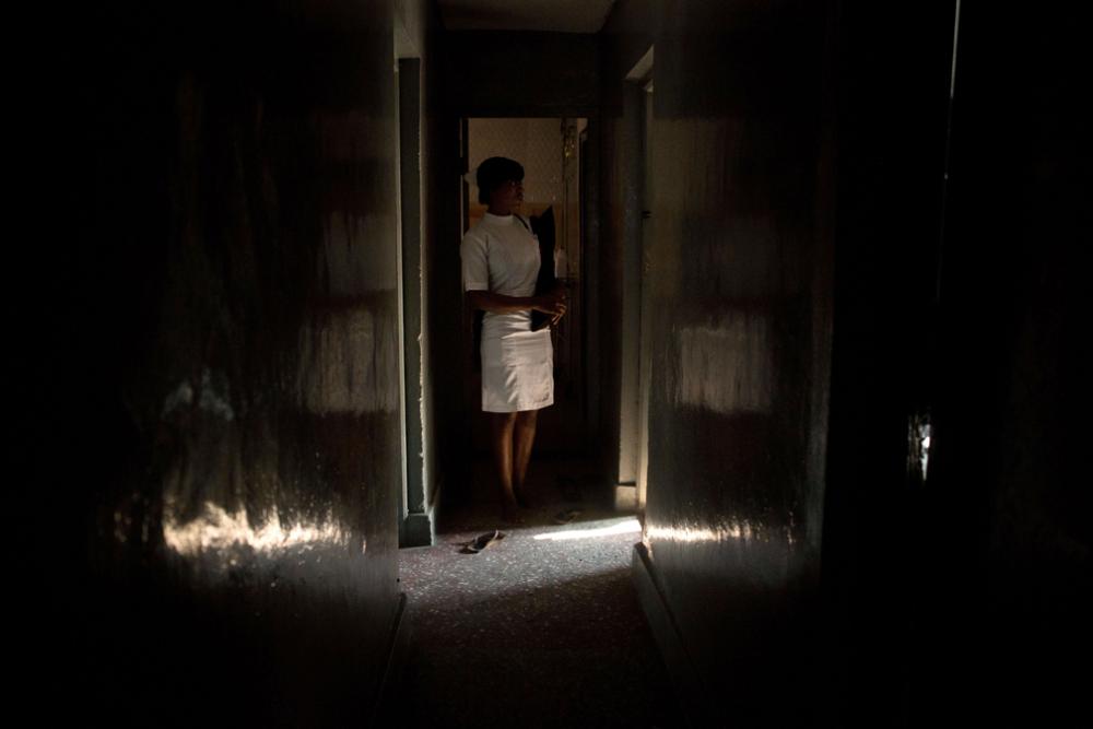 A member of the medical staff of a licensed doctor known for providing abortions stands in doorway of the operating room of his private clinic, located blocks from one of the biggest public hospitals in Lagos, Nigeria. They asked that their identities not be disclosed. Image by Allison Shelley. Nigeria, 2013.