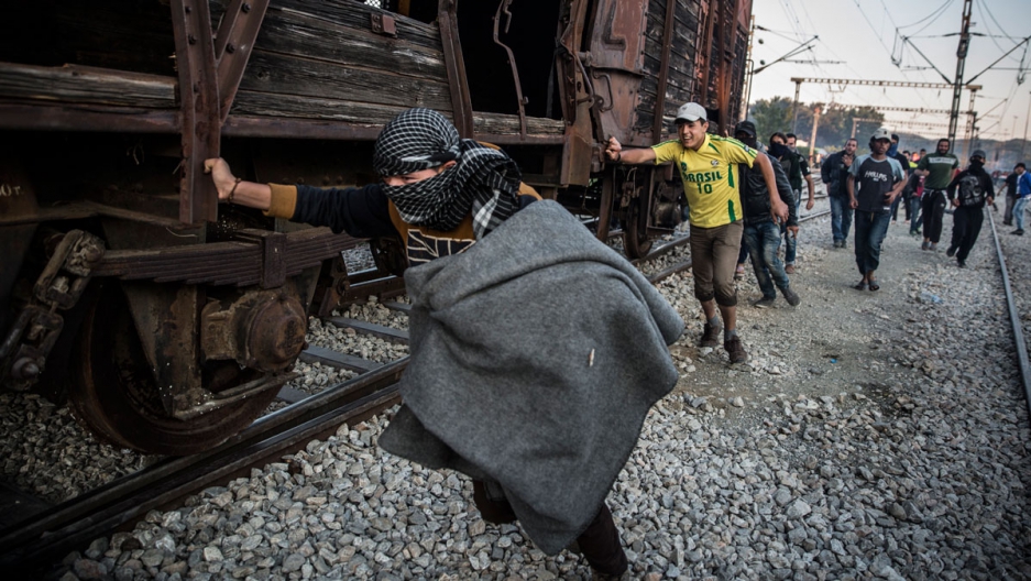Protesting migrants pushed an abandoned train wagon toward the border during a protest on May 18 at Idomeni camp. Clashes ensued between Greek police, who fired tear gas and stun grenades and immigrants. Image by Jodi Hilton. Greece, 2016. Media file: 051916_protest_idomeni_01_web_lede.jpg