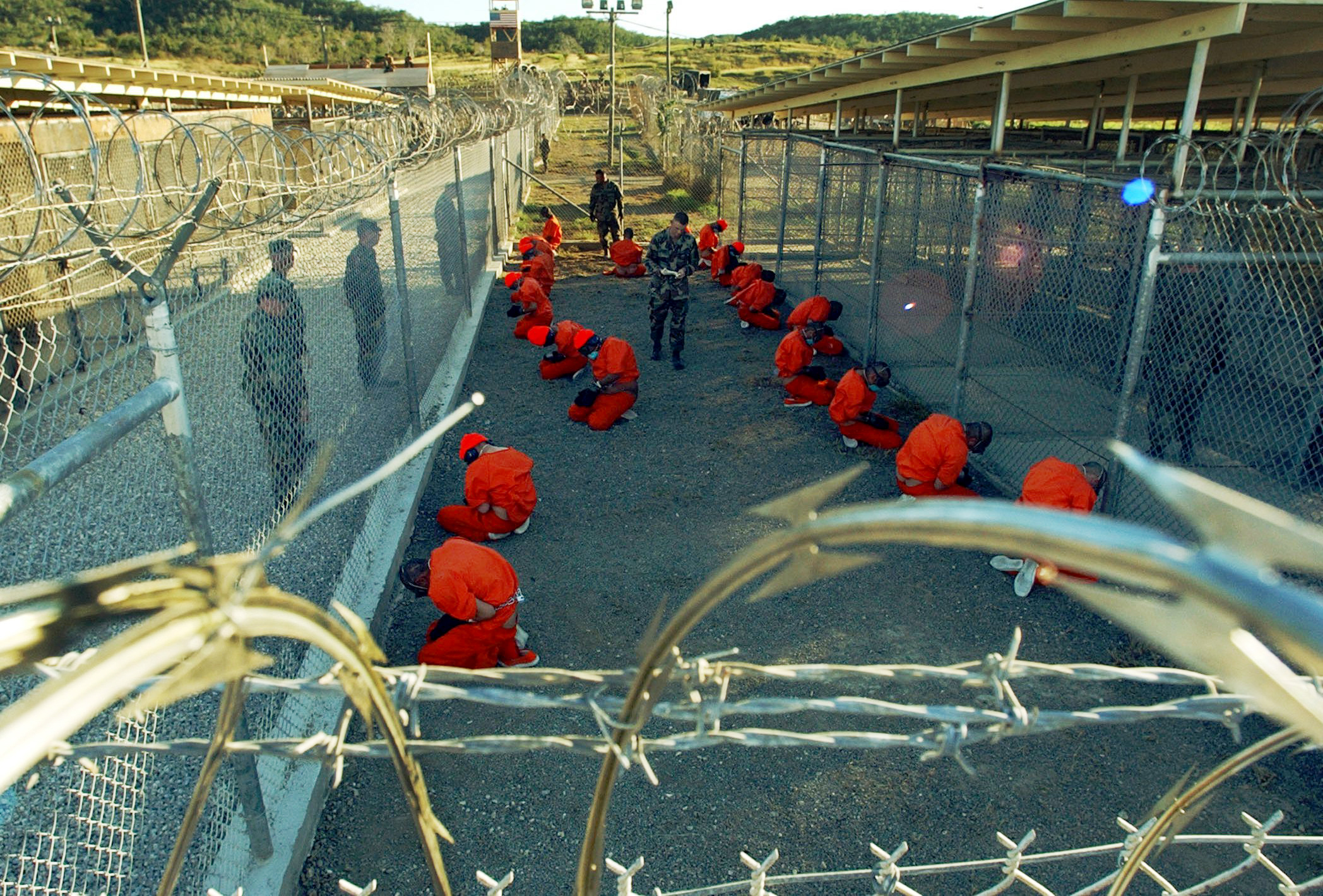 Guantánamo Bay detainees sit in a holding area at Camp X-Ray on January 11, 2002. Image courtesy of the Pentagon by Shane T. McCoy. Guantánamo Bay detainees sit in a holding area at Camp X-Ray on January 11, 2002. Image courtesy of the Pentagon by Shane T. McCoy.