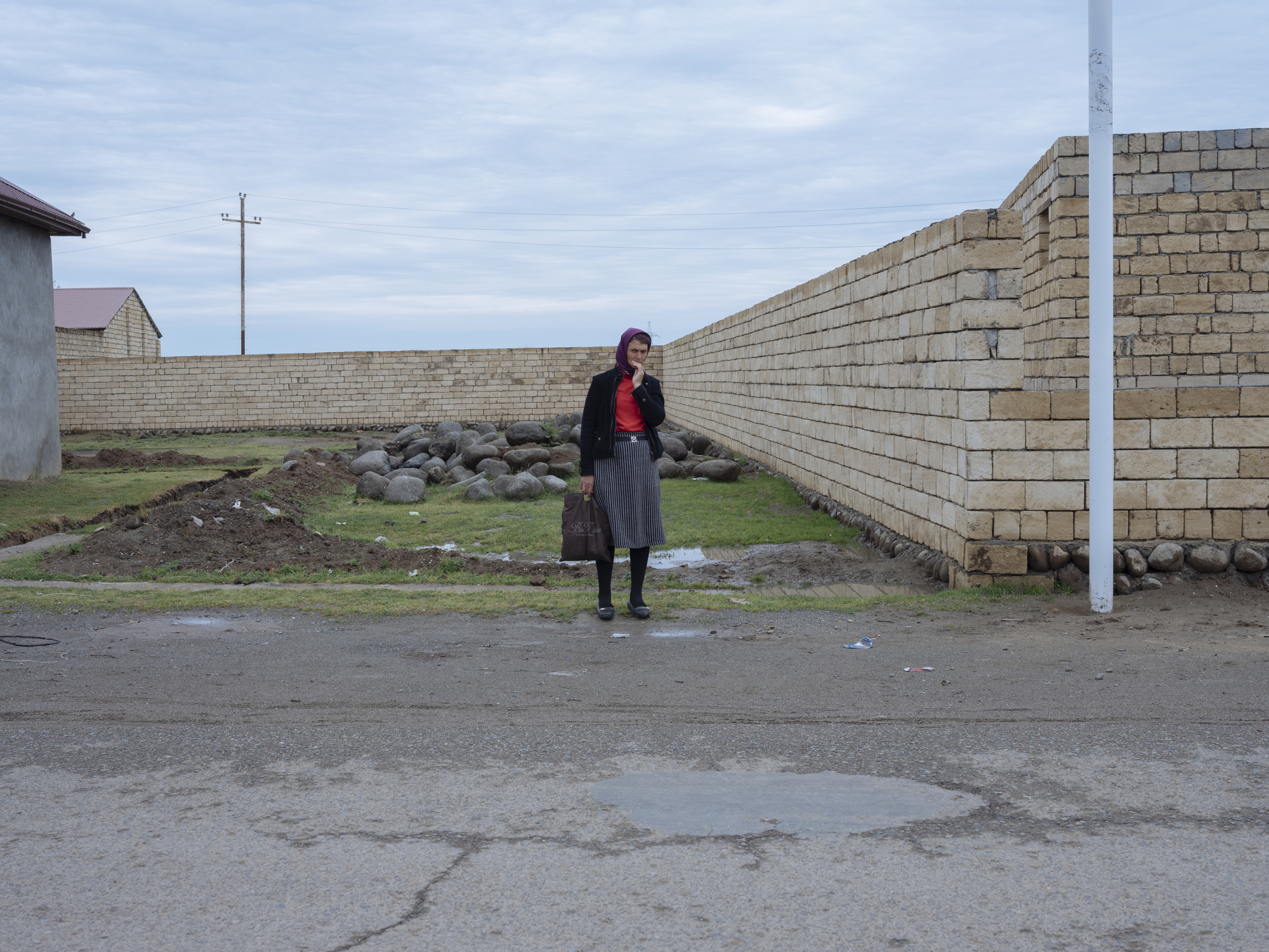 A woman waits for the village bus in Senceredi village. Image by Emin Ozmen / Magnum Photos. Azerbaijan, 2018. A woman waits for the village bus in Senceredi village. Image by Emin Ozmen / Magnum Photos. Azerbaijan, 2018.