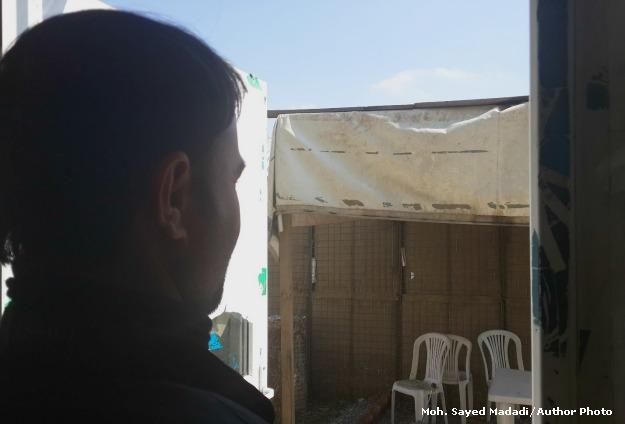 Norullah, who didn't want his face to be shown, looks on in a corner of the Independent Election Commission's compound. Image by Moh. Sayed Madadi. Afghanistan, 2014. Media file: cleaner_edit.jpg