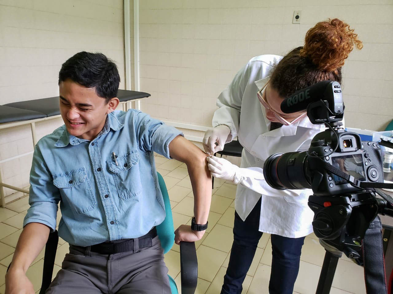 2020 Reporting Fellow Anton L. Delgado grimaces as Raquel Bouth, a Ph.D. student studying microbiology, takes a sample from the olecranal skin on his left elbow. This was the final part of Delgado’s leprosy evaluation that he took after nearly a month of field work in northern Brazil. Image by Moises Silva. Brazil, 2020. 2020 Reporting Fellow Anton L. Delgado grimaces as Raquel Bouth, a Ph.D. student studying microbiology, takes a sample from the olecranal skin on his left elbow. This was the final part of Delgado’s leprosy evaluation that he took after nearly a month of field work in northern Brazil. Image by Moises Silva. Brazil, 2020.