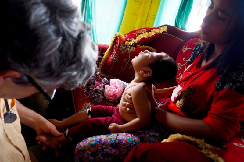 Stephan Bose-O'Reilly, a pediatrician and environmental health expert, examines two-year-old Rifky Aldiansyah, who lives in the village of Cisitu, for symptoms of mercury poisoning. Rifky was in good health until his third month when he began losing motor control. Rifky's mother, right, who lived in Cisungsang, a nearby mining community, said her home there was surrounded by gold processing centers. Mercury poisoning is “a serious health problem” for children in Indonesia, Bose-O'Reilly says. Image by Larry C. Price. Indonesia, 2016. Media file: larry_price_indonesia.jpg