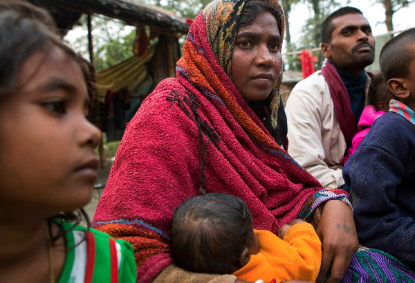 Sonia Devi, 35, holds her 2-month-old daughter Lovely, as she sits with her family at her home in a village in Begusarai, Bihar one afternoon in December. Sonia was sterilized a few days earlier. She has three other children besides Lovely—Suraj, 10, Laxmi, 6, and Badal, 2—and decided she didn't want to have a fifth. Image by Sarah Weiser. India, 2014. Media file: d91370d8-aff1-404c-b359-5f24ac67cdef.jpg