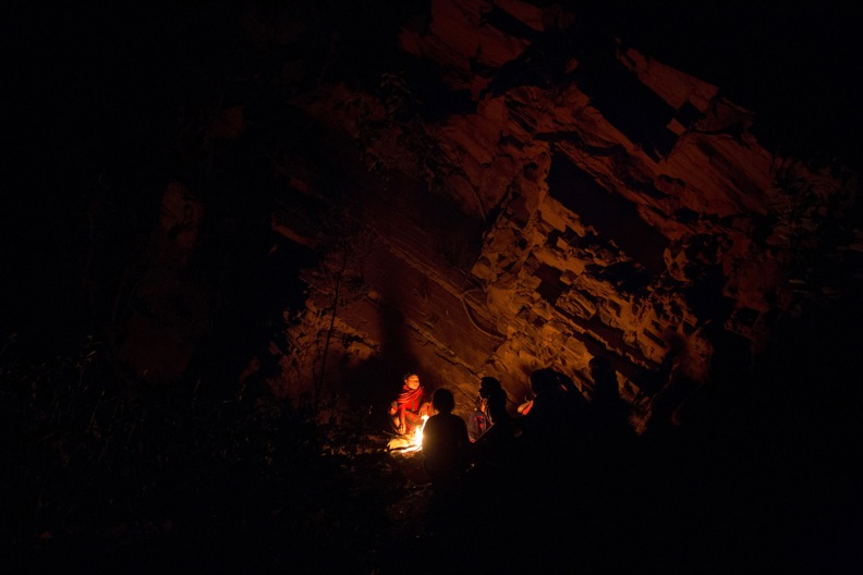 A group of women and girls chat around a fire as they prepare to sleep under a rock outcropping in observance of chaupadi in Kalekanda village, Achham, Nepal, December 18, 2012. The space, shared by all of the village women, provides no protection from the elements. Image by Allison Shelley. Nepal, 2012. Media file: stn_alsjj_chaupadi_09.jpg