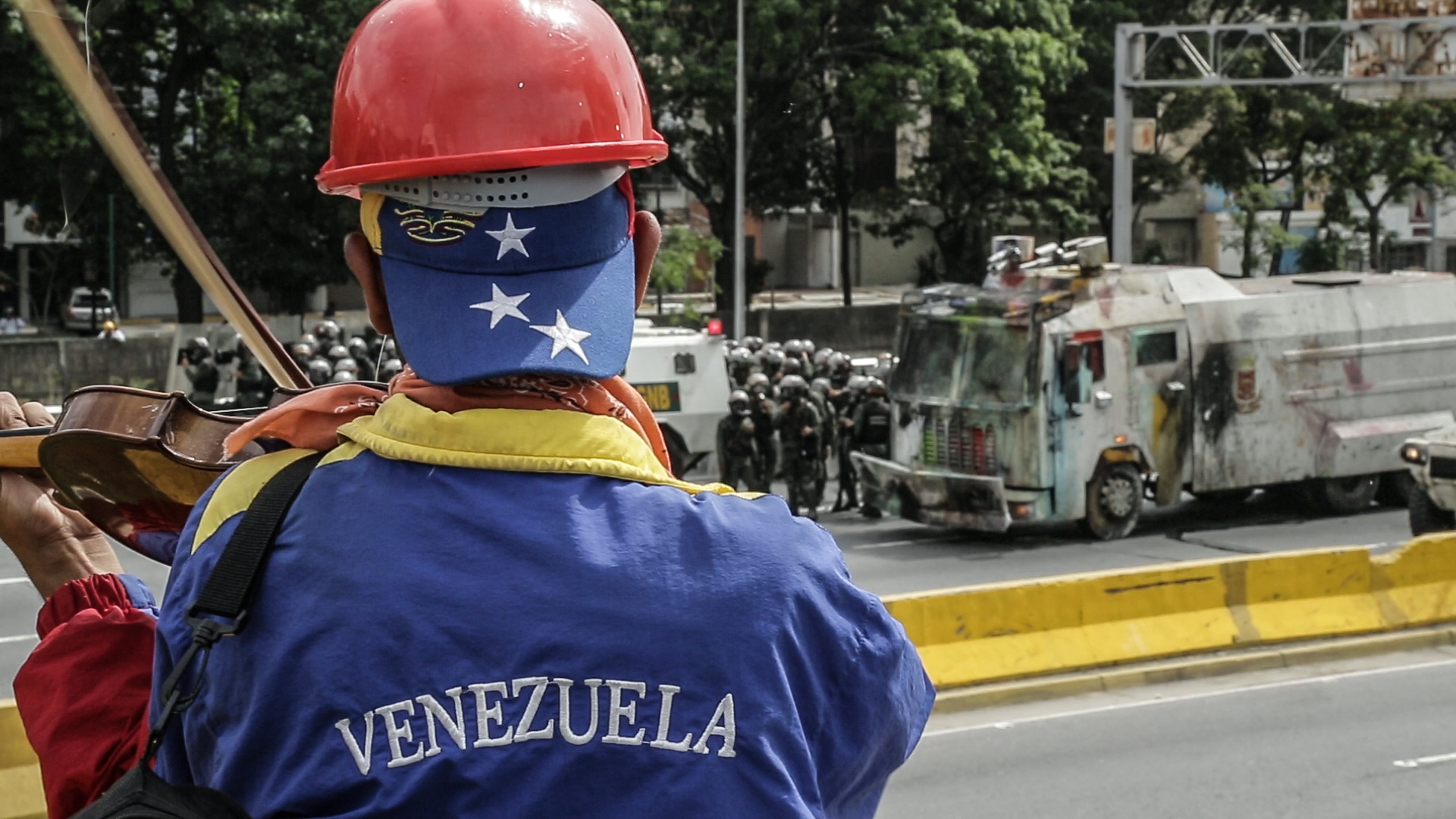 A violinist plays in front of Venezuelan National Guard during an anti-government protest in Caracas. Image by Bruno Federico. Venezuela, 2017. A violinist plays in front of Venezuelan National Guard during an anti-government protest in Caracas. Image by Bruno Federico. Venezuela, 2017.