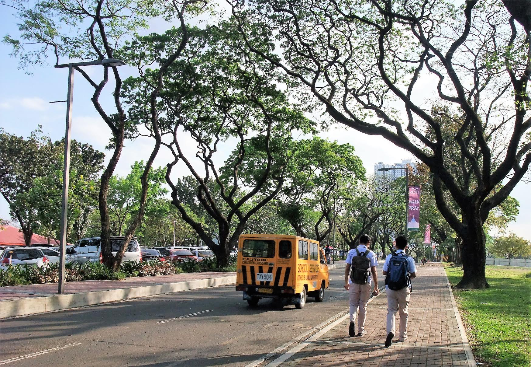 Ateneo’s solution: Build and maintain a network of wide sidewalks. Take care of old trees so that their canopy can shield the people who walk from the elements. Image by Dinna Louise C. Dayao. Philippines, 2017. Ateneo’s solution: Build and maintain a network of wide sidewalks. Take care of old trees so that their canopy can shield the people who walk from the elements. Image by Dinna Louise C. Dayao. Philippines, 2017.