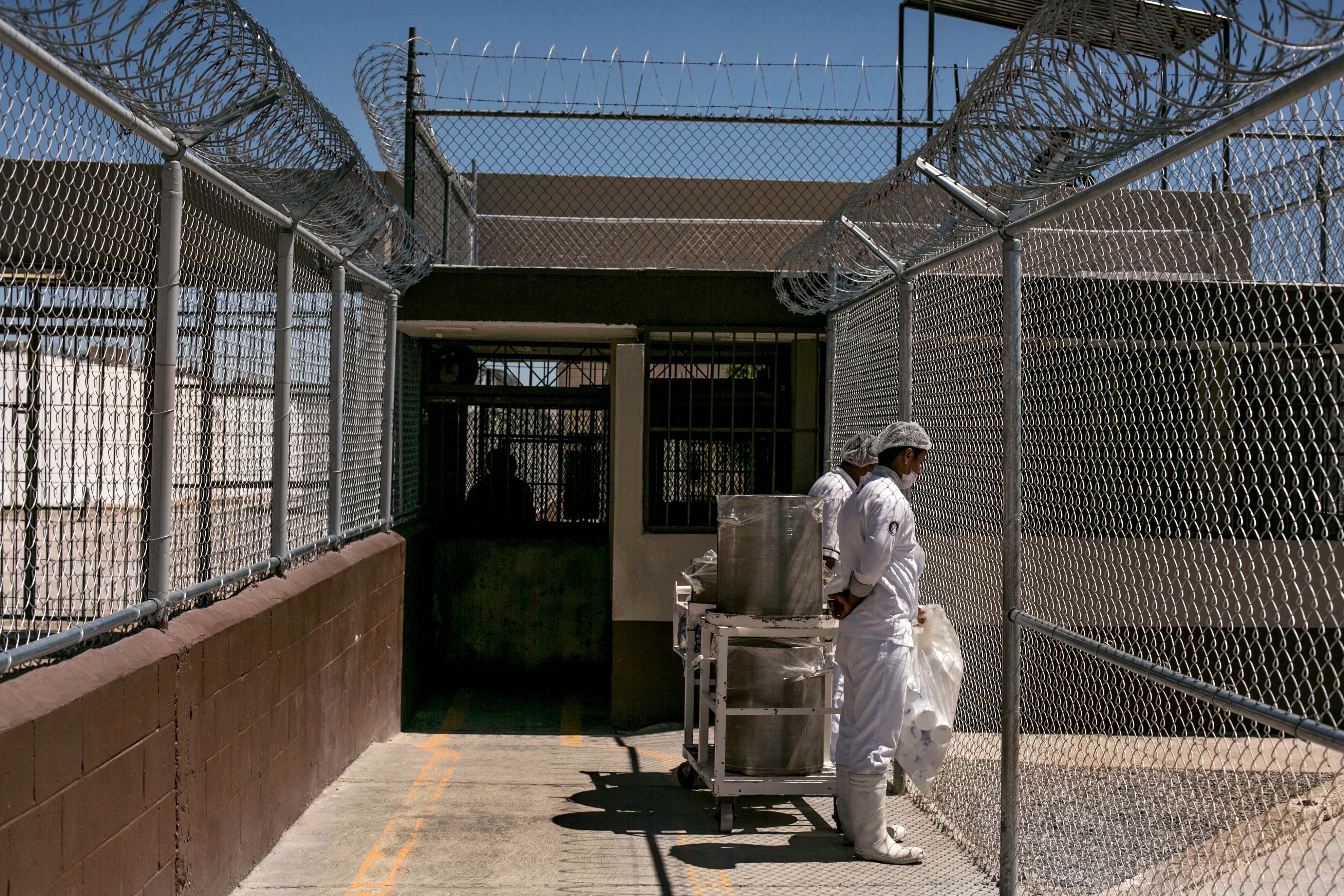Two inmates at the CERESO Estatal No. 3 move food between sections of the prison. In earlier days the prison was run by gangs, but now the guards are back in control. Image by Dominic Bracco II. Mexico, 2016. Media file: mm8388_150407_03187.jpg