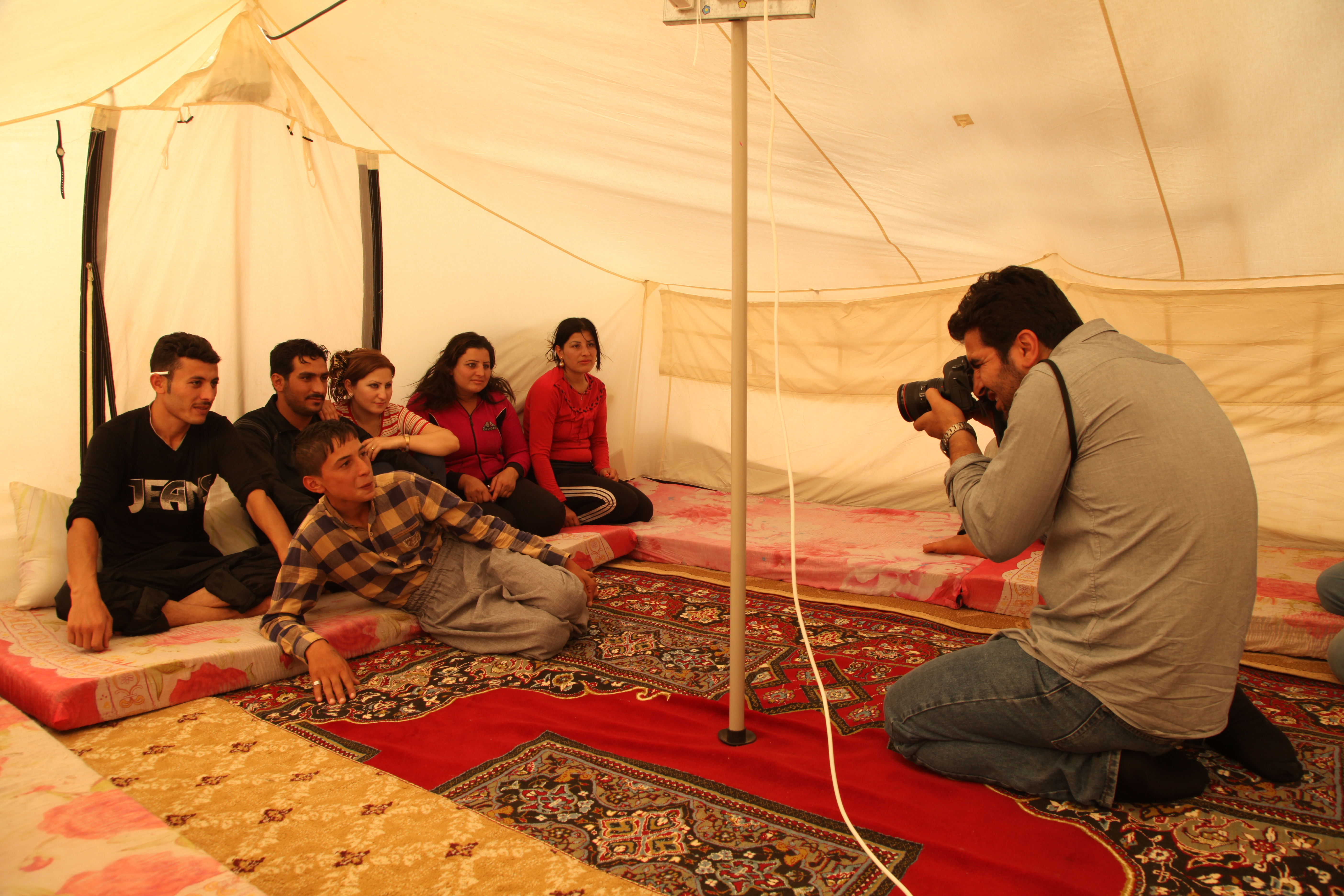 Kamaran Najm takes a portrait of a family of Syrian refugees in Arbat, Iraq, on October 17, 2013. Image by Sebastian Meyer. Iraq, 2013.