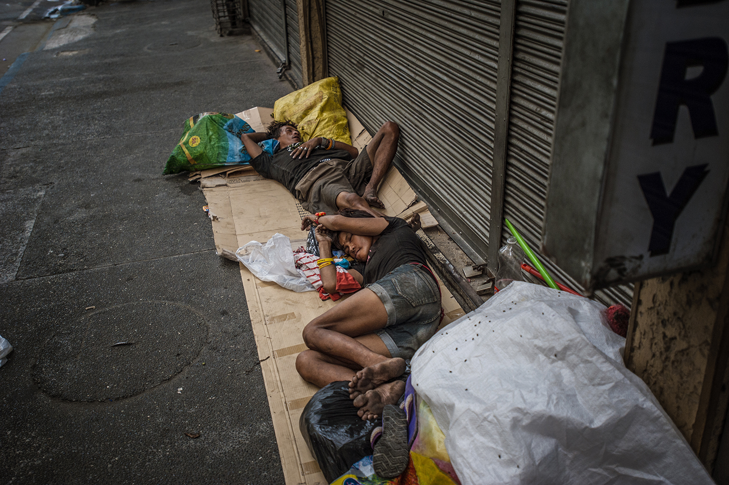 Many families sleep on Mabini Street of Malate, Manila, often suffering not only from poverty but substance abuse problems. By May 2016, a little over one month before the inauguration of Philippine President Rodrigo Duterte, extrajudicial killings have taken the lives of over 8,000 Filipinos. As of June 2017, almost all the homeless who sleep on Mabini Street are no longer there, their whereabouts unknown. Image by James Whitlow Delano. Philippines, 2016. Many families sleep on Mabini Street of Malate, Manila, often suffering not only from poverty but substance abuse problems. By May 2016, a little over one month before the inauguration of Philippine President Rodrigo Duterte, extrajudicial killings have taken the lives of over 8,000 Filipinos. As of June 2017, almost all the homeless who sleep on Mabini Street are no longer there, their whereabouts unknown. Image by James Whitlow Delano. Philippines, 2016.