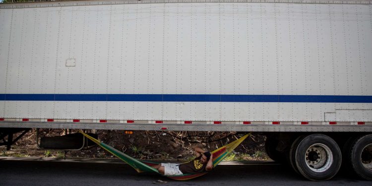 There is a constant image that extends along 17 km accumulated of trucks: that of a driver lying in his hammock. Luis Aguilar kills time, like hundreds of his colleagues. Image by César Arroyo. Nicaragua, 2020. There is a constant image that extends along 17 km accumulated of trucks: that of a driver lying in his hammock. Luis Aguilar kills time, like hundreds of his colleagues. Image by César Arroyo. Nicaragua, 2020.