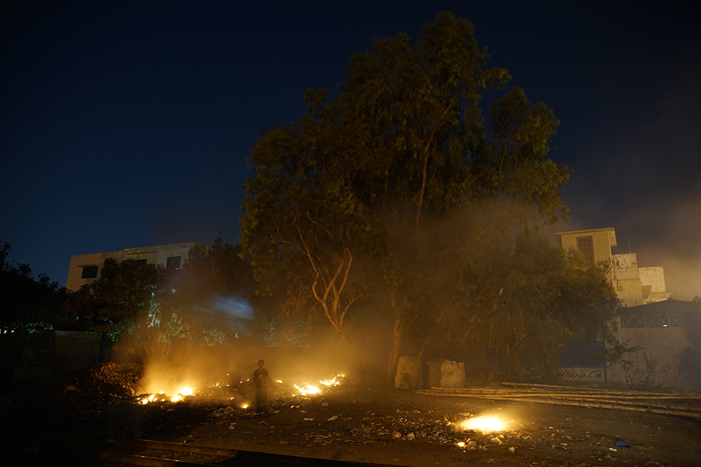 Trash fires light up the Karachi night, a symbol of the city's lawlessness. Karachi suffered over 3,200 violent killings in 2013 -- over 10,600 in the last four years. Image by Ivan Sigal. Pakistan, 2014. Media file: dsc01924sml.jpg