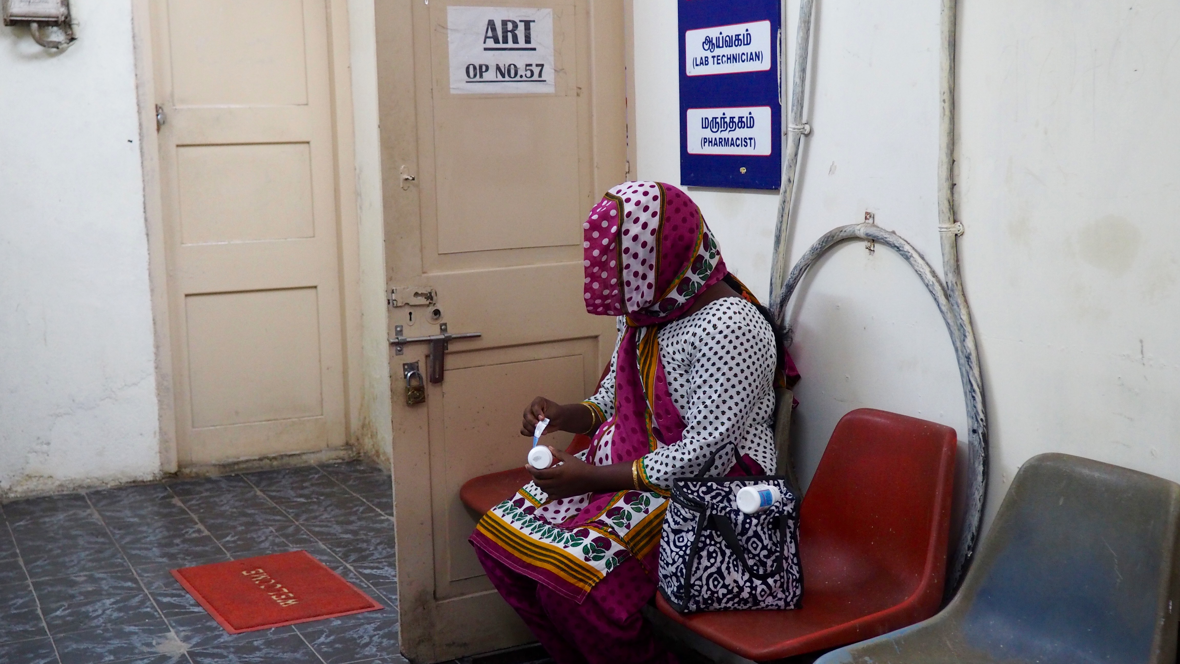 An HIV-positive woman the peels the labels off her medication at the government ART center so that her family members will not discover her HIV status. Image by Adita Kantipuly. India, 2016 Media file: katipuly-india_health_center.jpg