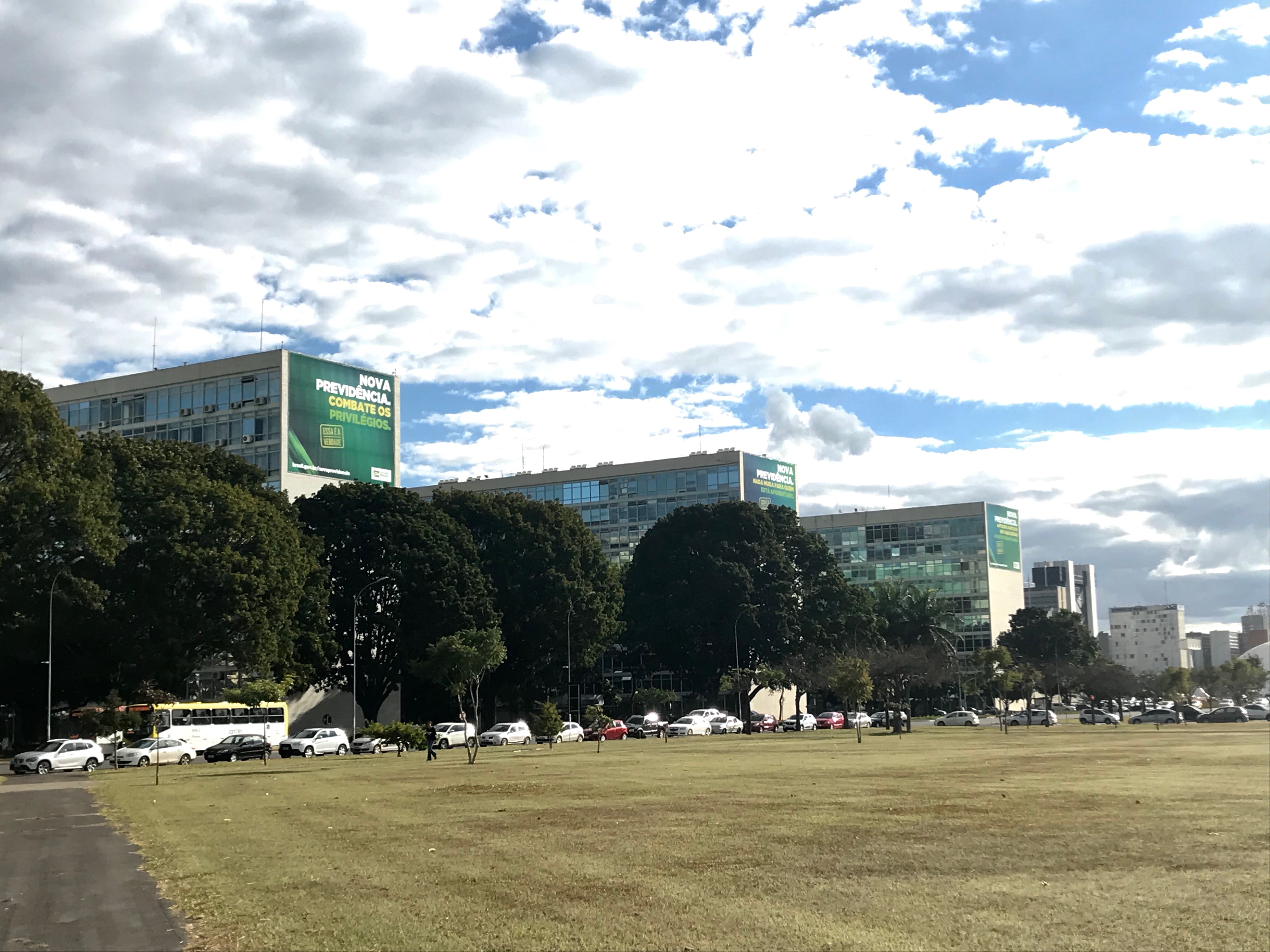 As part of an unprecedented marketing strategy, the government under Bolsonaro decided to put billboards showing the benefits of their unpopular social security reform in front of each ministry building. This is the first time in Brazil’s history that the ministries were used for marketing purposes. Image by Rafael Lima. Brazil, 2019. As part of an unprecedented marketing strategy, the government under Bolsonaro decided to put billboards showing the benefits of their unpopular social security reform in front of each ministry building. This is the first time in Brazil’s history that the ministries were used for marketing purposes. Image by Rafael Lima. Brazil, 2019.