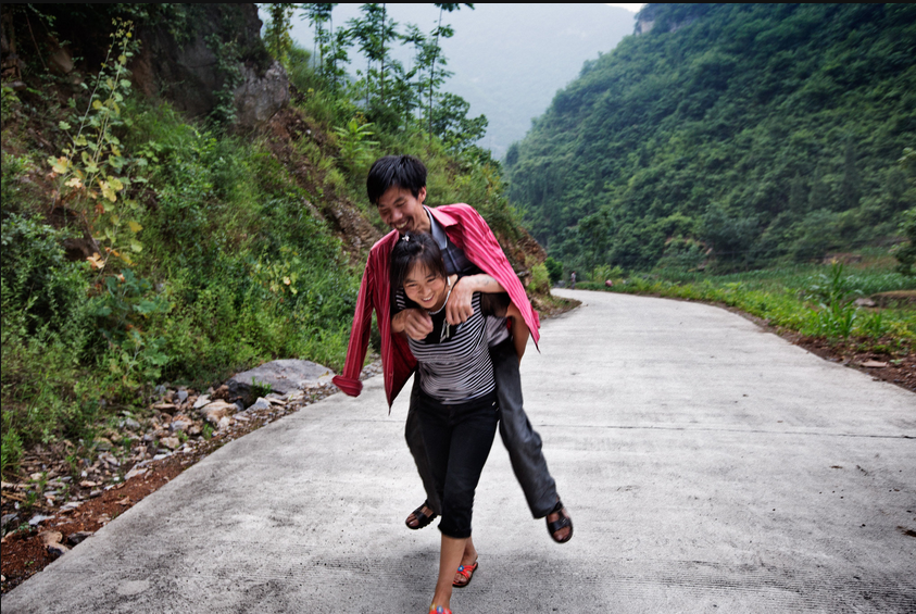 He Quangui, a former gold miner, is slowly dying of silicosis—an irreversible but preventable lung disease he contracted from years of working in small, unregulated mines in Henan Province in central China. Since he became ill 10 years ago, his wife, Mi Shixiu, 36, has had to take care of his every need. When he is too sickly to walk, she carries him, even up flights of stairs. Image by Sim Chi Yin. China, 2015. Media file: screen_shot_2015-06-23_at_10.26.43_am_0.png
