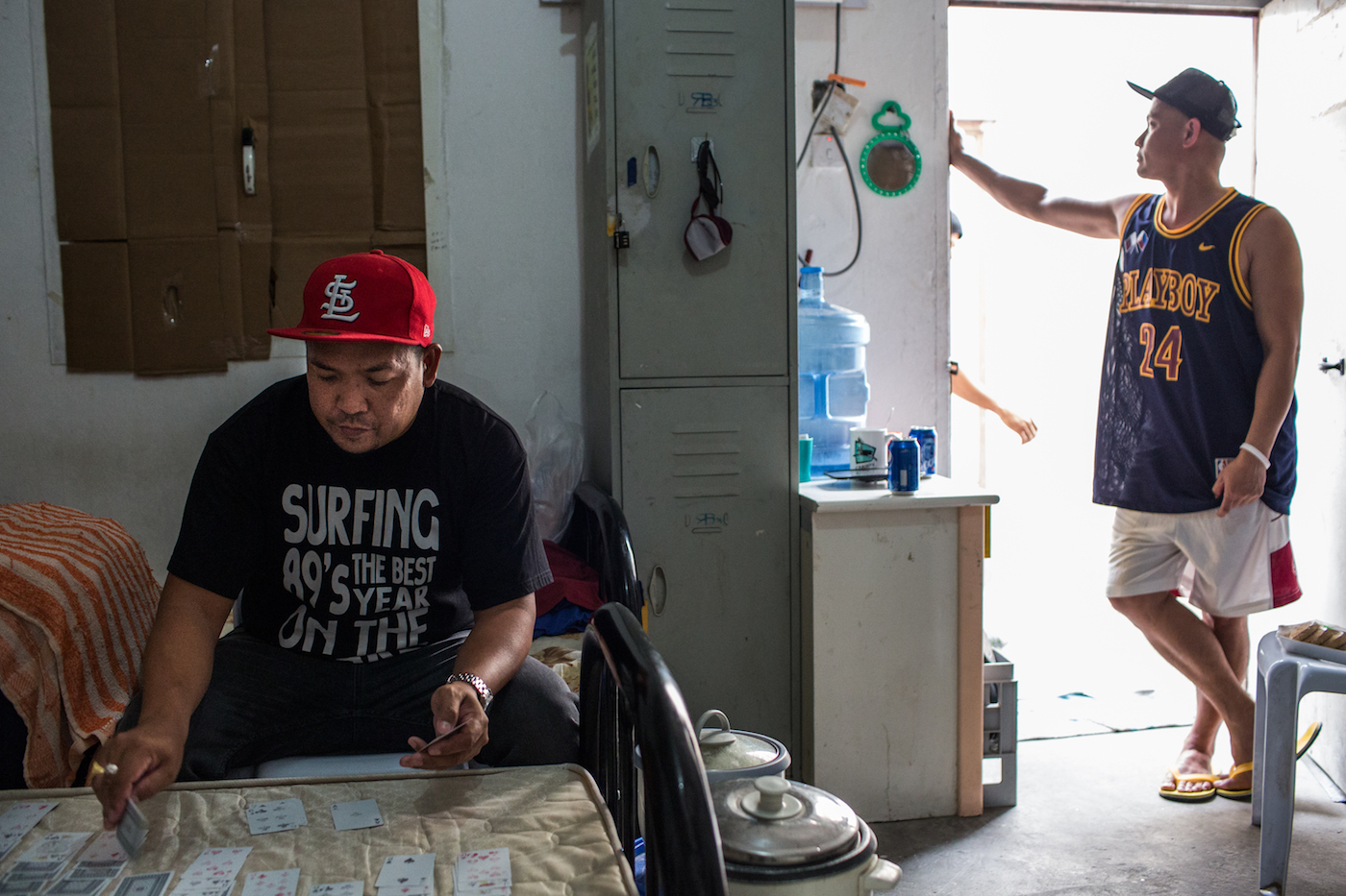 Romeo plays cards to make time pass. He and other workers are not paid by the company since January 2017. They stay in the camp waiting for their case to be processed. Image by Hans Lucas. Qatar, 2017. Romeo plays cards to make time pass. He and other workers are not paid by the company since January 2017. They stay in the camp waiting for their case to be processed. Image by Hans Lucas. Qatar, 2017.