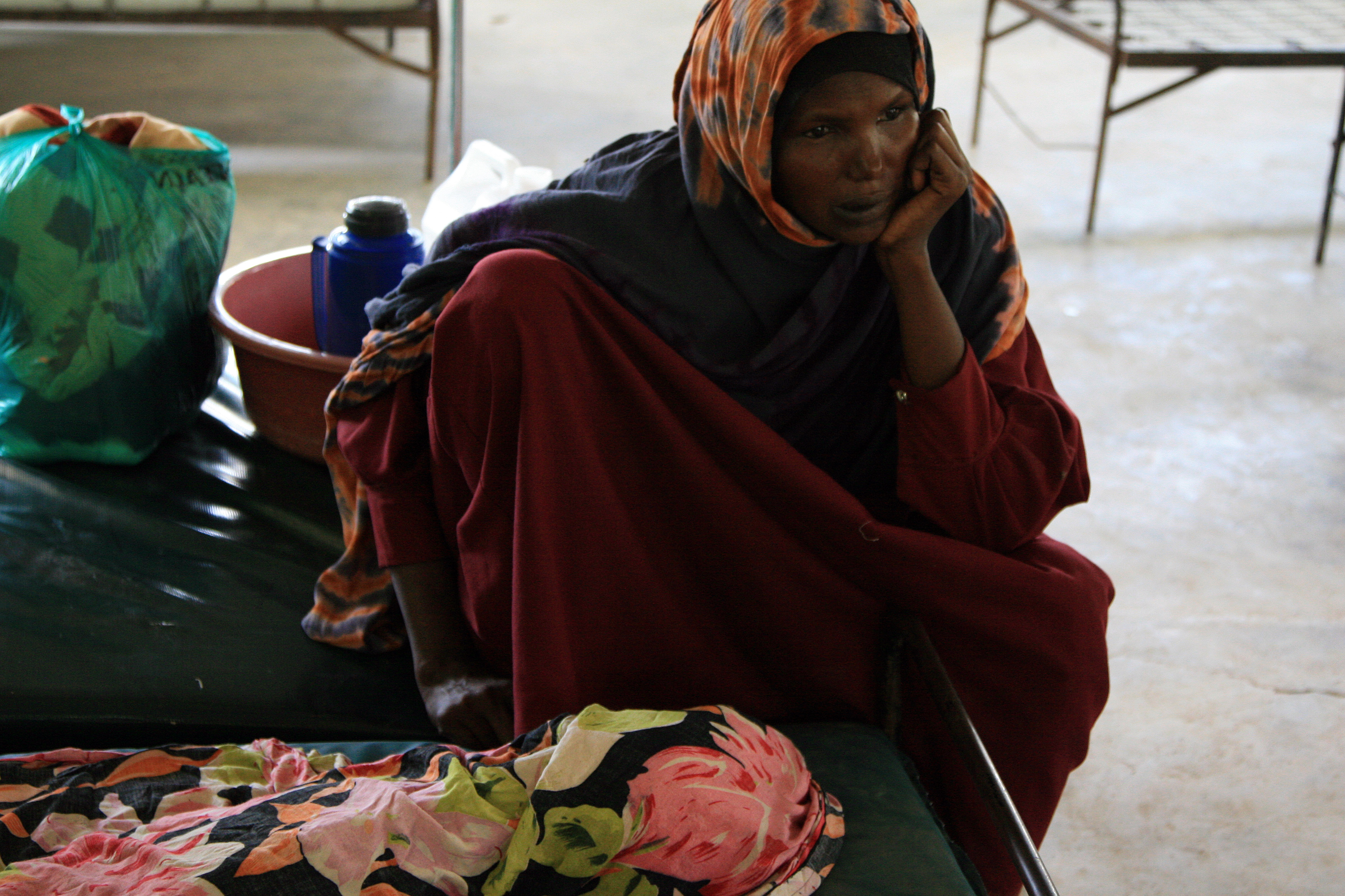 A Somali woman grieves over the loss of her 2-year-old nephew, who is wrapped in a blanket. He died from complications of kwashiorkor, a malady caused by a protein deficiency that occurs when children are weaned too soon to make room for a younger sibling. Image by Kenneth R. Weiss. Media file: kwashgrief.jpg