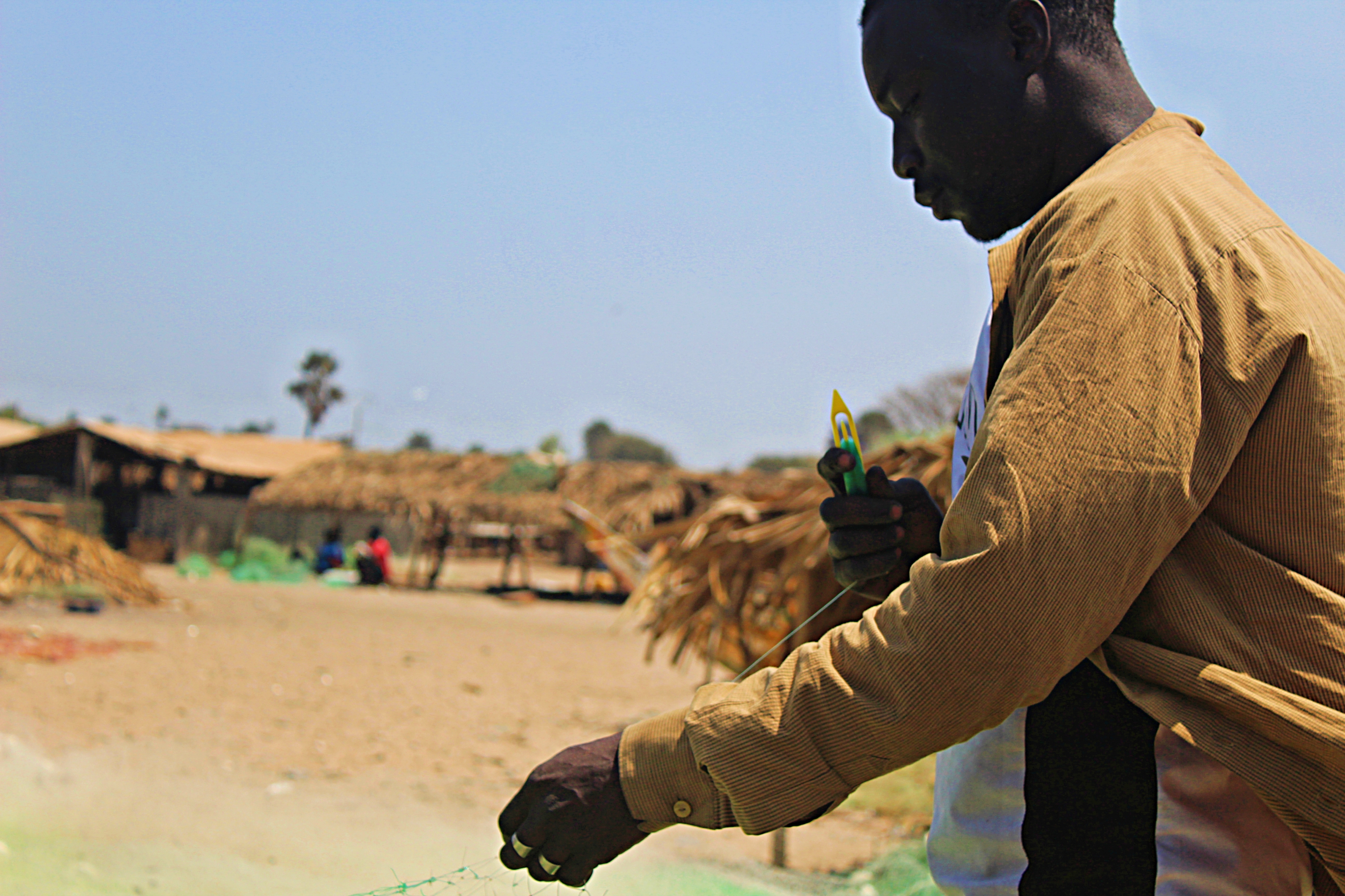 Edrissa Sackh and his captain Abdulai Camara mend their fishing net on Gunjur beach. These small-scale fishermen catch the majority of fish critical to food security. Image by Nosmot Gbadamosi. Gambia, 2018. Edrissa Sackh and his captain Abdulai Camara mend their fishing net on Gunjur beach. These small-scale fishermen catch the majority of fish critical to food security. Image by Nosmot Gbadamosi. Gambia, 2018.