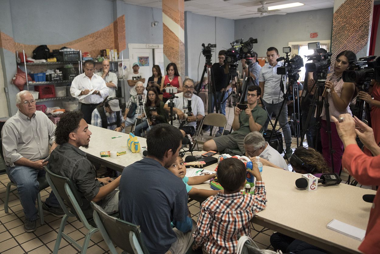 Left to right: Director of the Annunciation House Ruben Garcia, Roger (only first names given), Pablo Ortiz and his 3-year-old son Andres (off frame) and 4-year-old Roger Jr. speak to the media during a press conference at the Annunciation House in El Paso on July 11, 2018. The fathers and sons were released the previous night by ICE. Image by Ivan Pierre Aguirre for the Texas Tribune. United States, 2018.