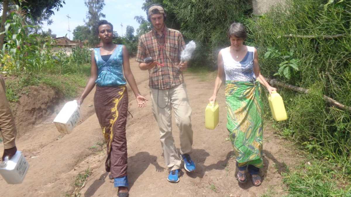 Radio producer Wyatt Orme records audio as Irene Homvelt (right) participates in a "Culture Tour" in Rwanda. Image by Wyatt Orme. Rwanda, 2015. Media file: l_culturetour1200.jpg