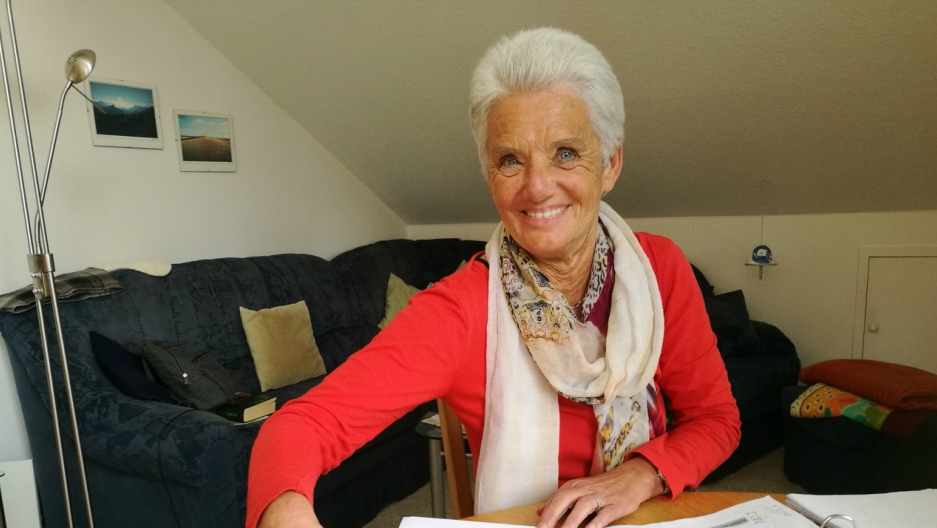 Christa Schmidt is pictured at the table in her apartment in Traunreut, where she tutors refugees in German. Schmidt’s parents were German refugees from Romania. Image by Frank Hessenland. Germany, 2017. Christa Schmidt is pictured at the table in her apartment in Traunreut, where she tutors refugees in German. Schmidt’s parents were German refugees from Romania. Image by Frank Hessenland. Germany, 2017.