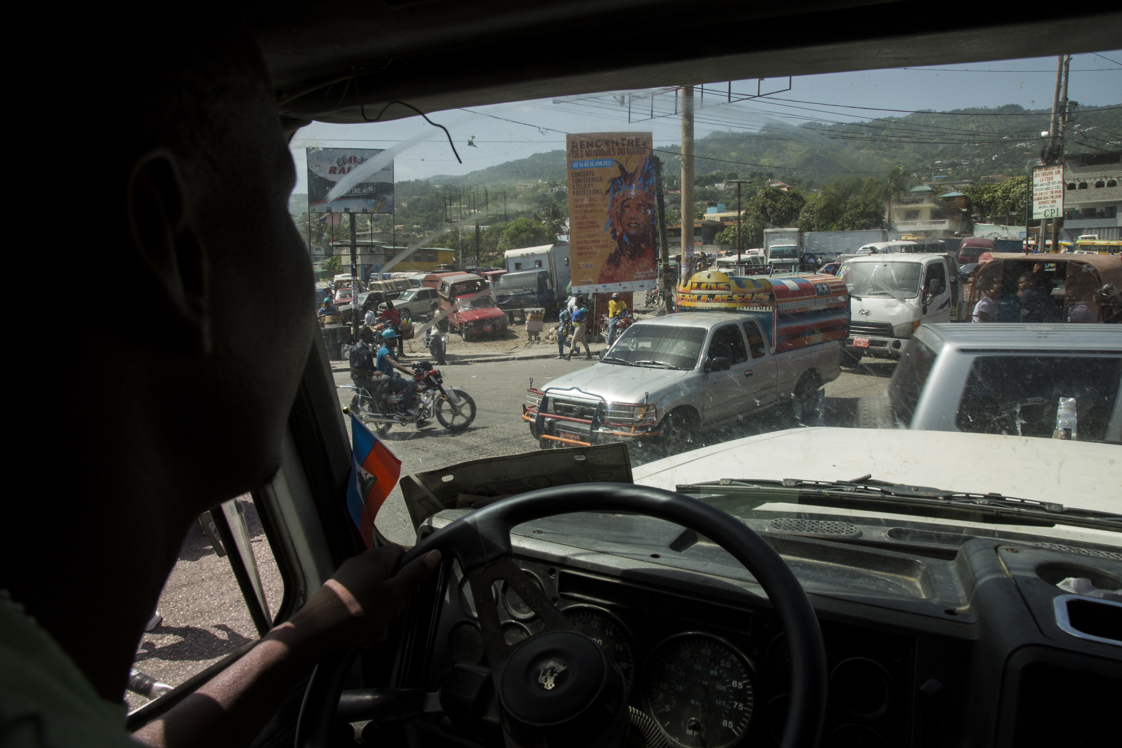 Traffic in downtown Port-au-Prince, Haiti. Elide Jean Petrus, 46, drives a truck through traffic in downtown Port-au-Prince, Haiti. Image by Marie Arago. Haiti, 2017.