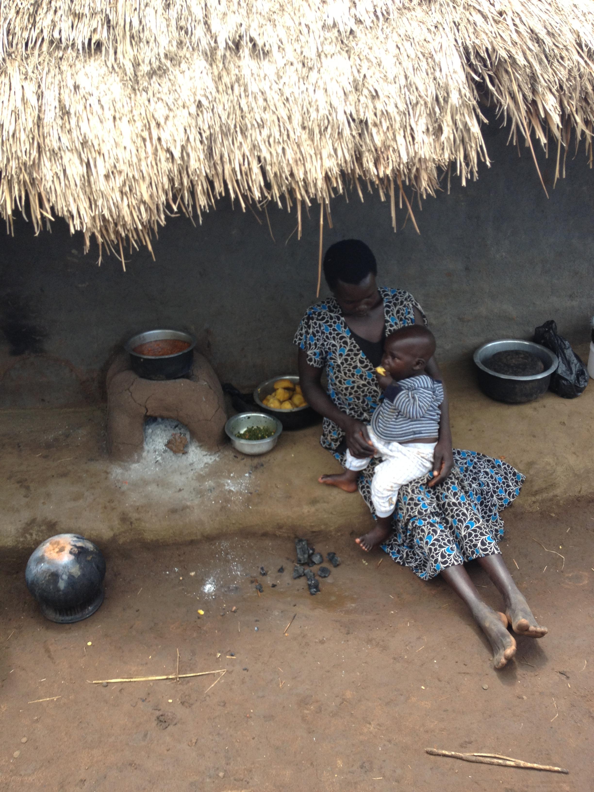 Lunchtime in northern Uganda. A mother and her child enjoy sweet potatoes rich in Vitamin A and beans with higher iron content. Image by Roger Thurow. Uganda, 2014.
