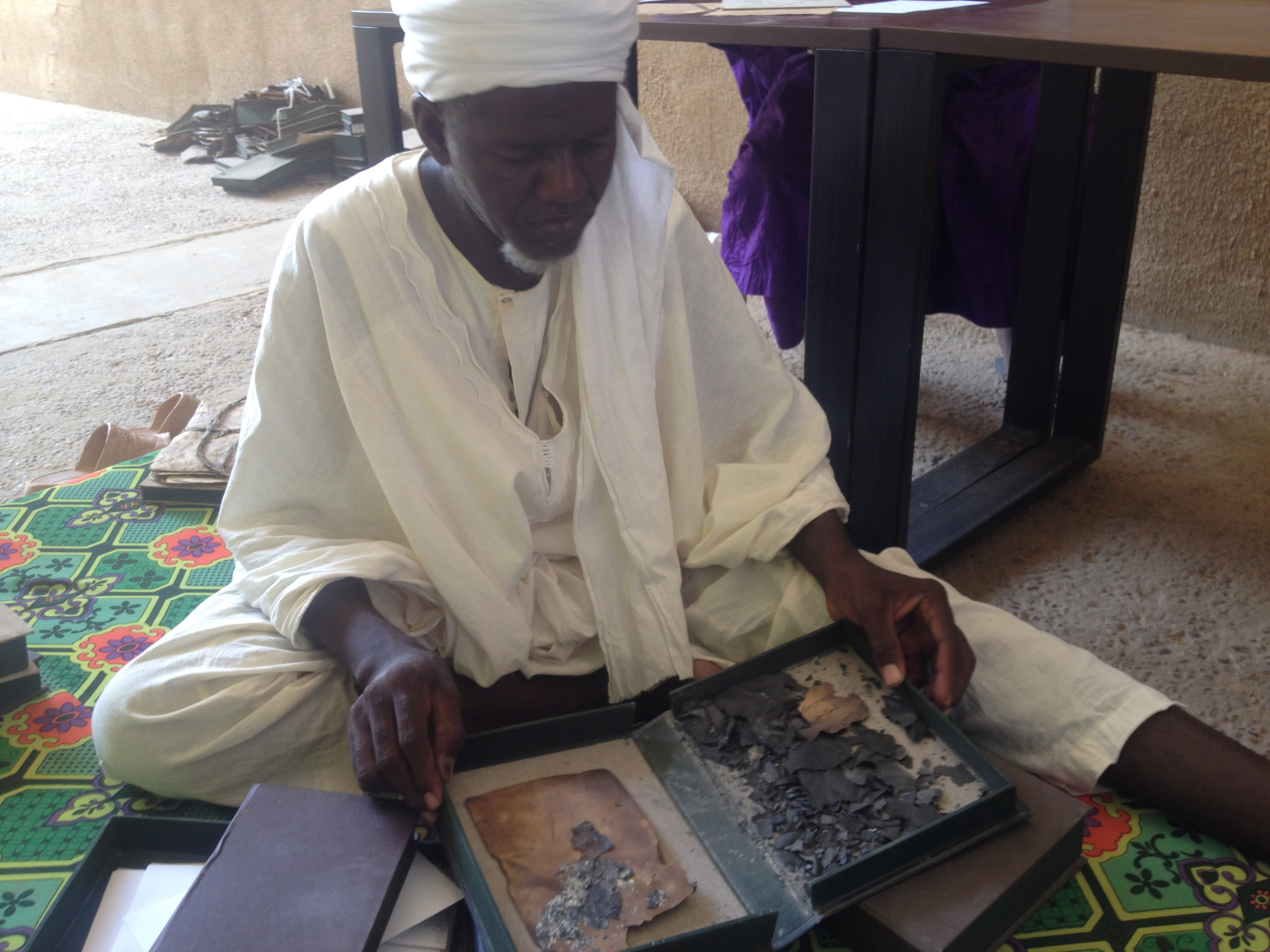 A librarian at Timbuktu's Ahmed Baba Institute displays the ashes from manuscripts burned by Al Qaeda militants in January 2013. Image by Joshua Hammer. Mali, 2013. Media file: img_1780.jpg
