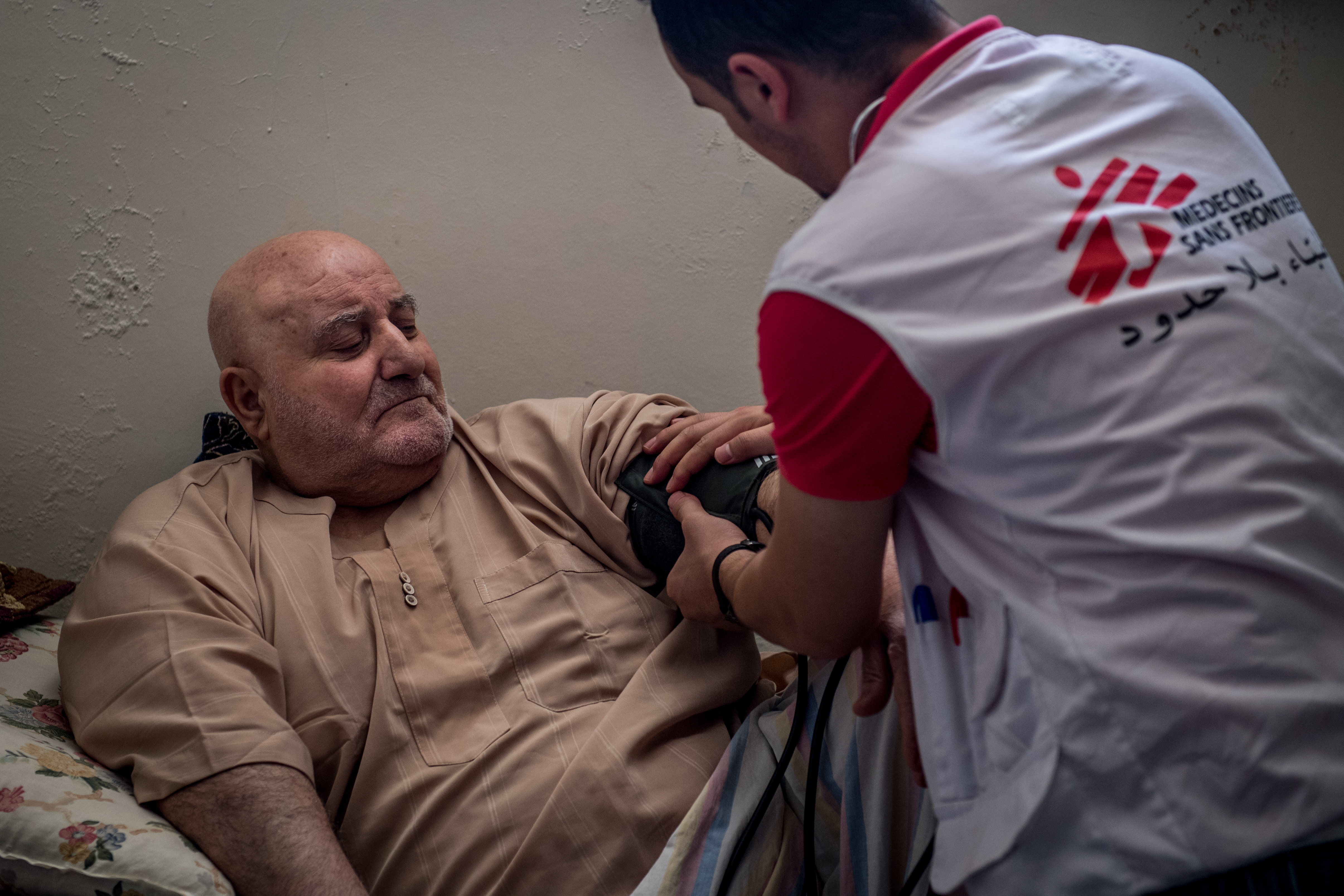 A physician checks on Ibrahim Hassan (left), who lives as a displaced person in Jordan after fleeing the regime in Syria. A physician checks on Ibrahim Hassan (left), who lives as a displaced person in Jordan after fleeing the regime in Syria. Image by Neil Brandvold. Jordan, 2017.