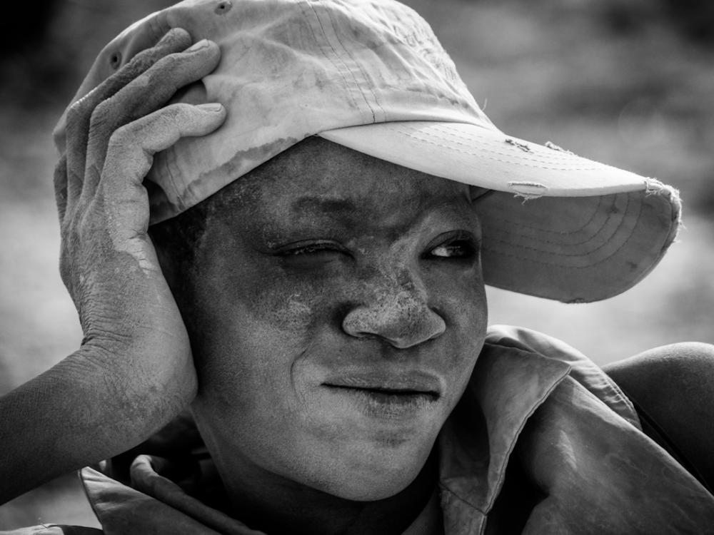 A young boy takes a break while sifting ore at Bilbalé. Image by Larry C. Price. Burkina Faso, 2013.