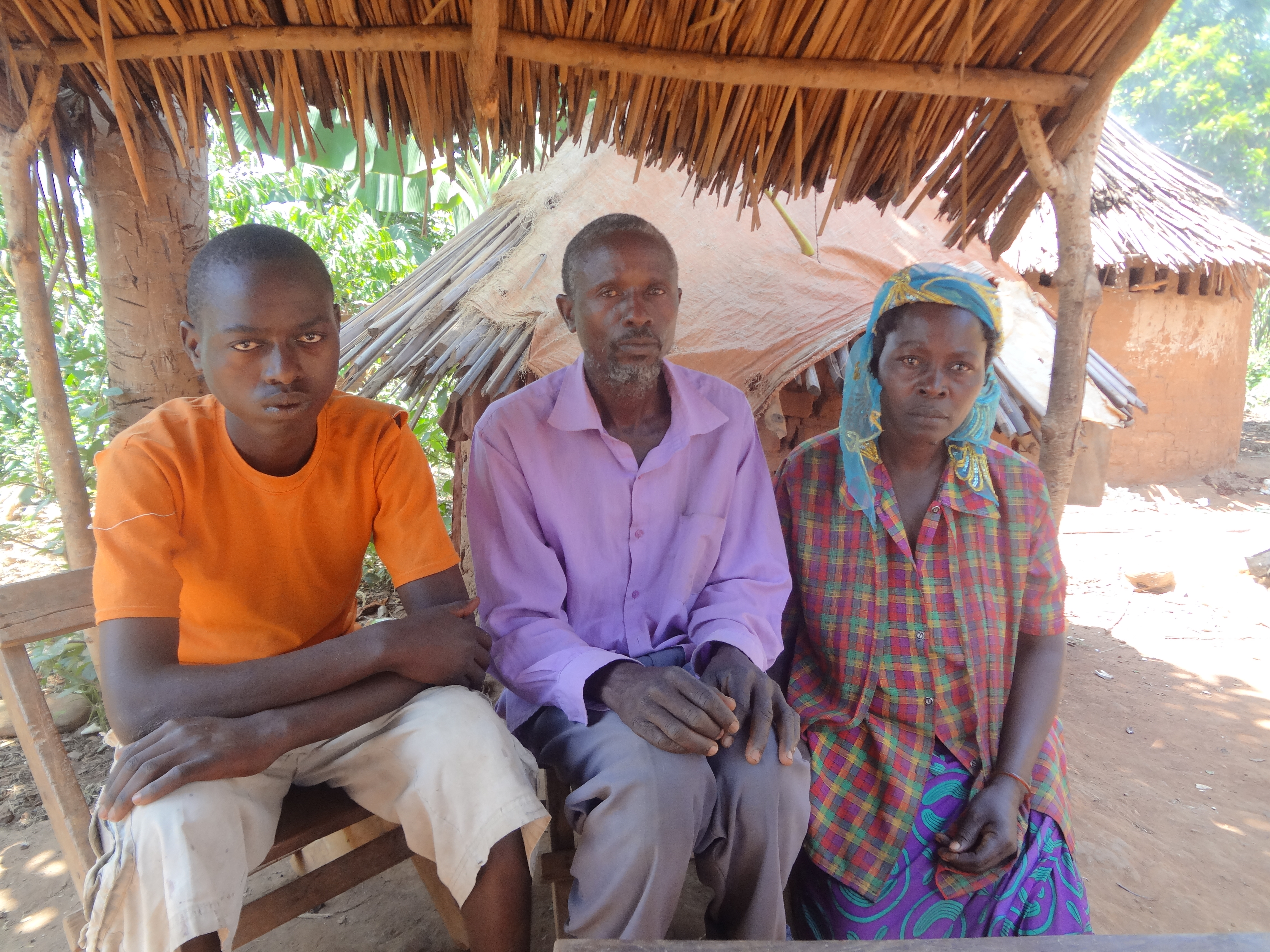 Waani Mubakalim (far left) with his father Tuusa George (middle) and his mother Alilwa Jessica (far right). George explains how his son, Mubakalim, became disabled. Image by Jae Lee. Uganda, 2015. Media file: 26.jpg