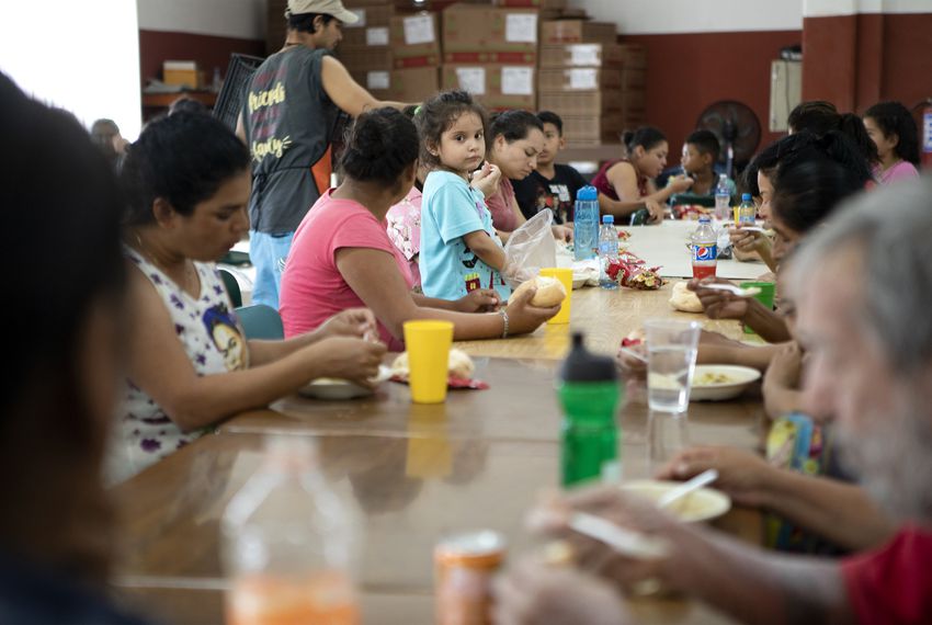 A young girl stands on a chair in the dining hall at Casa Indi in Monterrey, Nuevo Leon on Aug. 5, 2019. The Mexican government has been busing migrants away from the border and into the interior of the country. Image by Miguel Gutierrez Jr. Mexico, 2019. A young girl stands on a chair in the dining hall at Casa Indi in Monterrey, Nuevo Leon on Aug. 5, 2019. The Mexican government has been busing migrants away from the border and into the interior of the country. Image by Miguel Gutierrez Jr. Mexico, 2019.