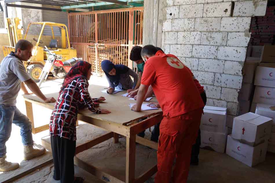 Aid workers checking a Syrian refugee's status on a municipal list in Hermel, Lebanon on July 27, 2013. Image by Hugh Eakin. Lebanon, 2013. Media file: hermel-6.jpg